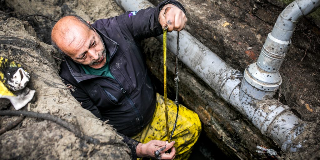 De fundering van een huis wordt onderzocht. Ongeveer een miljoen huizen dreigen te verzakken.