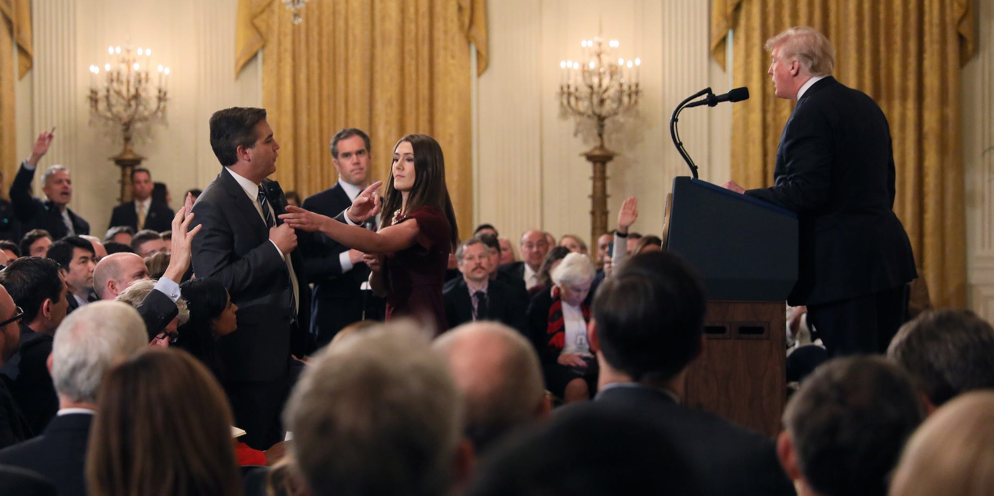 Een medewerker van het Witte Huis probeert een microfoon af te pakken van CNN-verslaggever Jim Acosta. Foto: Jonathan Ernst/Reuters