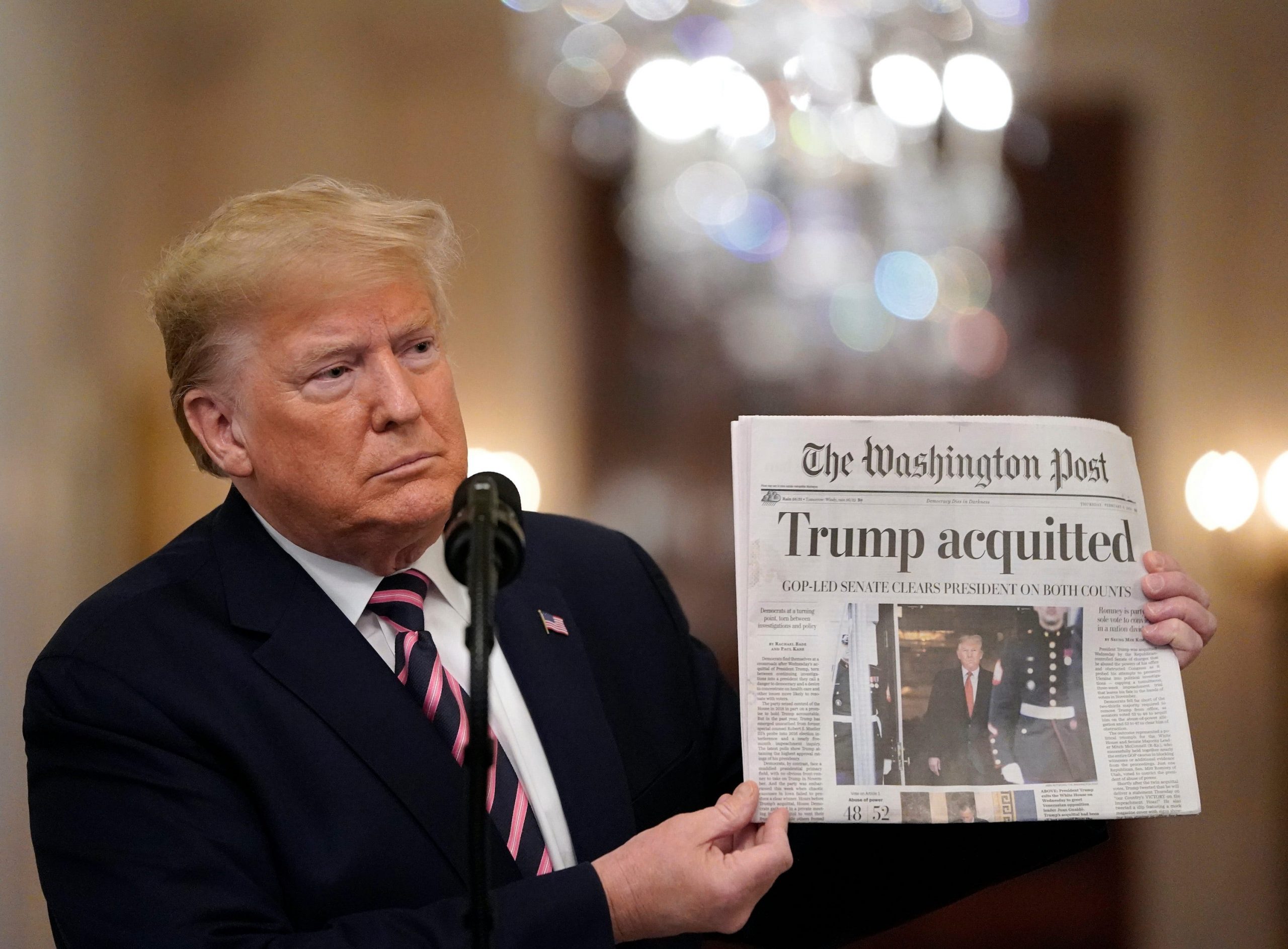 President Donald Trump houdt de voorpagina van The Washington Post omhoog, de dag nadat de Senaat hem vrij heeft gesproken van aanklachten van machtsmisbruik en het belemmeren van de rechtsgang, 6 februari 2020. Foto: Drew Angerer/Getty Images