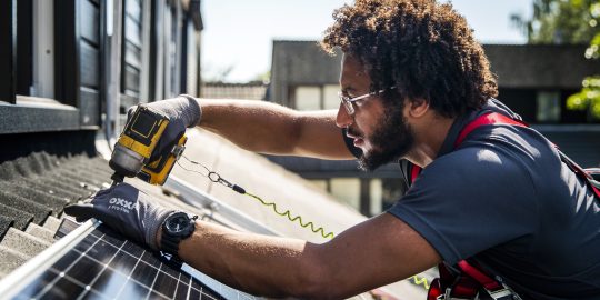 Een installateur plaatst zonnepanelen