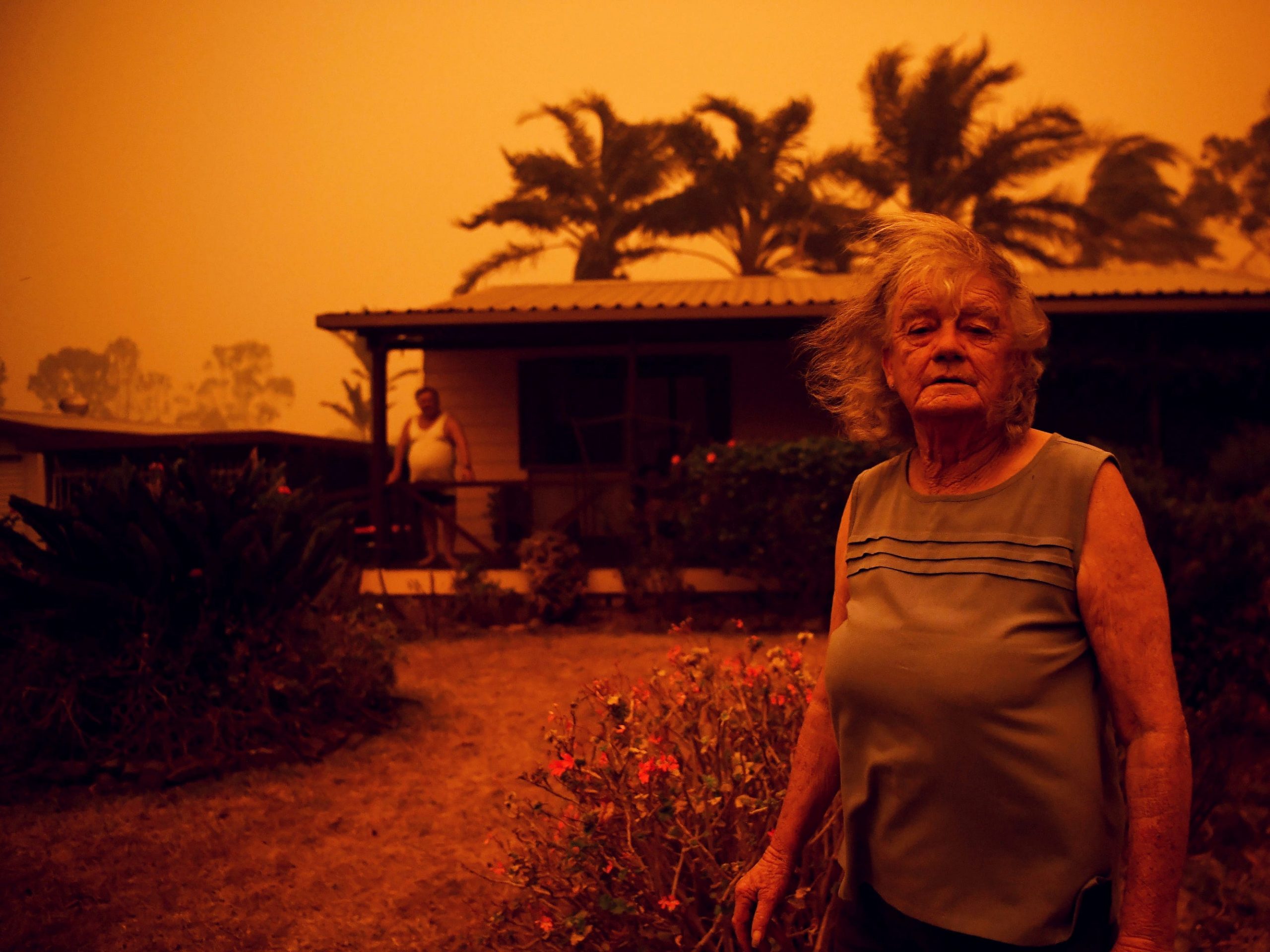 Nancy Allen and Brian Allen stand outside the house as high winds push smoke and ash from the Currowan Fire towards Nowra, New South Wales, Australia January 4, 2020. REUTERS/Tracey Nearmy