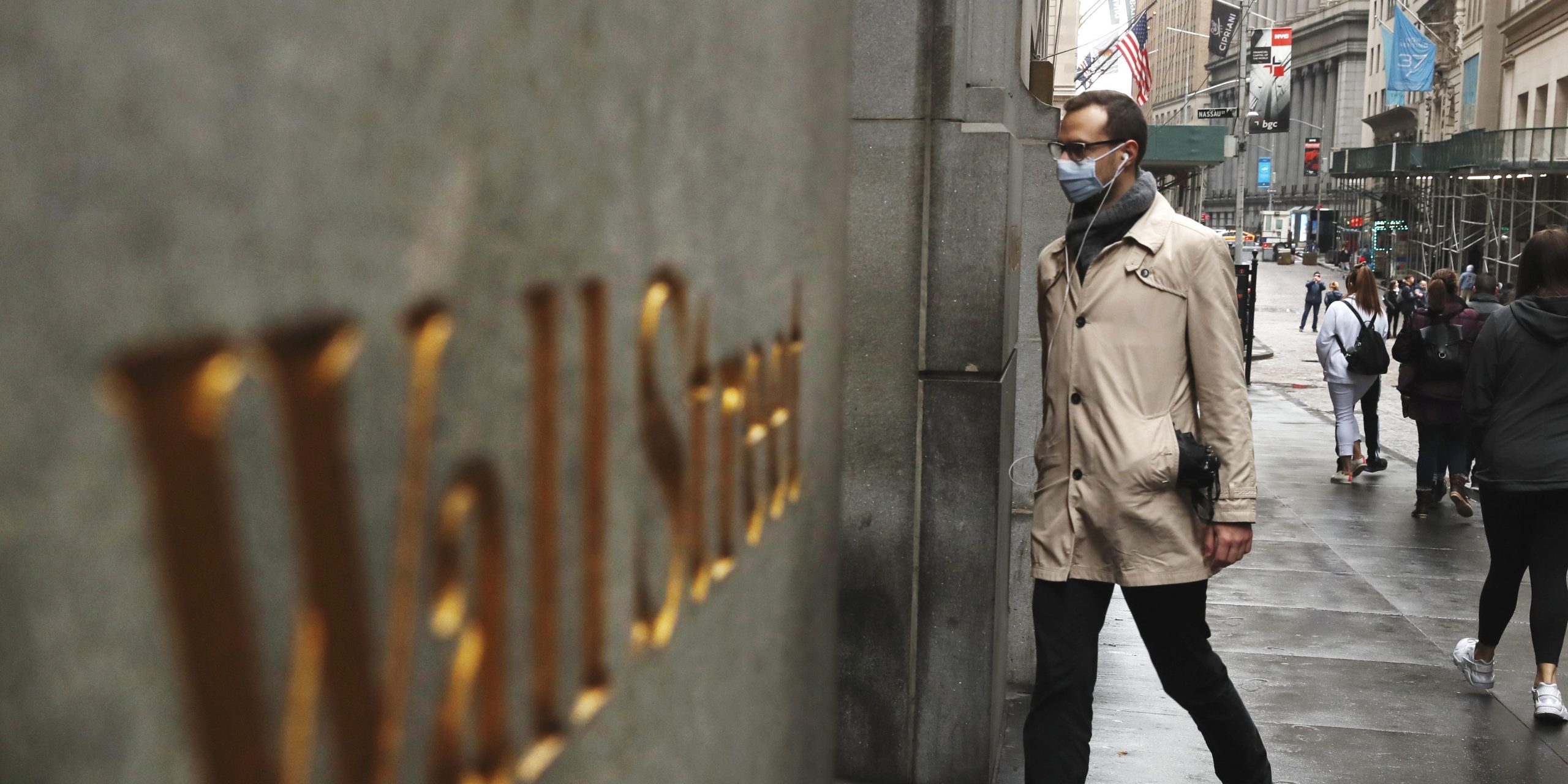 A man wears a protective mask as he walks on Wall Street during the coronavirus outbreak in New York