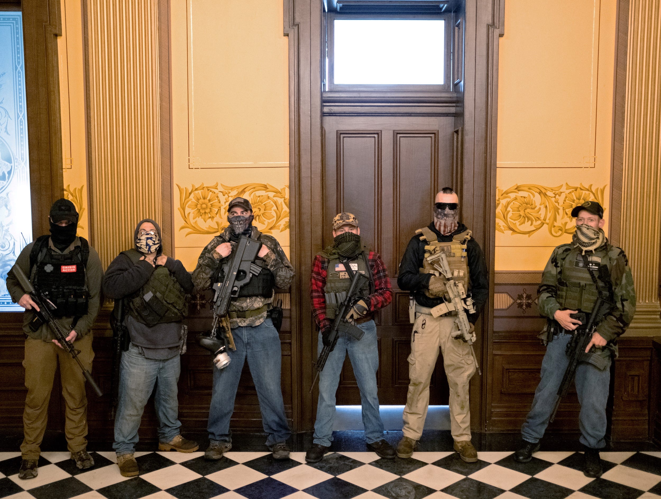 militia group with no political affiliation from Michigan, including Joseph Morrison (3rd R), Paul Bellar (2nd R) and Pete Musico (R) who were charged for their involvement in a plot to kidnap Michigan Governor Gretchen Whitmer, attack the state capitol building and incite violence, stand in front of the governor's office after protesters occupied the state capitol building during a vote to approve the extension of Whitmer's emergency declaration/stay-at-home order due to the coronavirus disease (COVID-19) outbreak, in Lansing, Michigan, U.S. April 30, 2020.