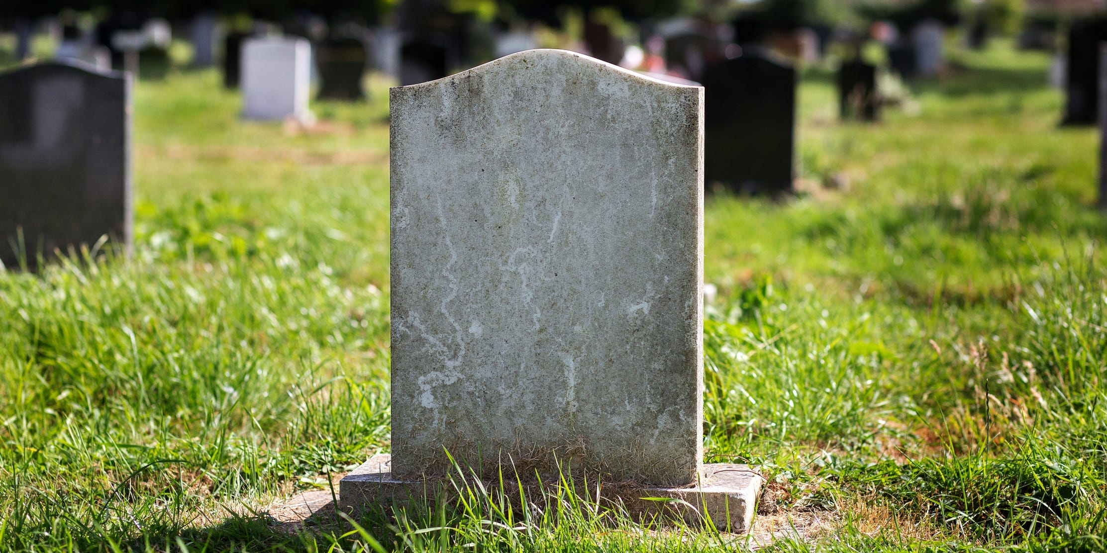 Blank gravestone with other graves in the background
