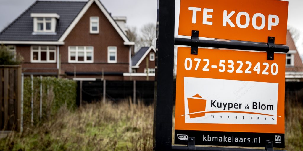 Een bord met te koop bij een woning.