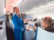 Een passagier ontvangt een certificaat van deelname tijdens KLM’s eerste vlucht met de Boeing 787 Dreamliner vanaf Amsterdam Schiphol.