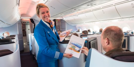 Een passagier ontvangt een certificaat van deelname tijdens KLM’s eerste vlucht met de Boeing 787 Dreamliner vanaf Amsterdam Schiphol.