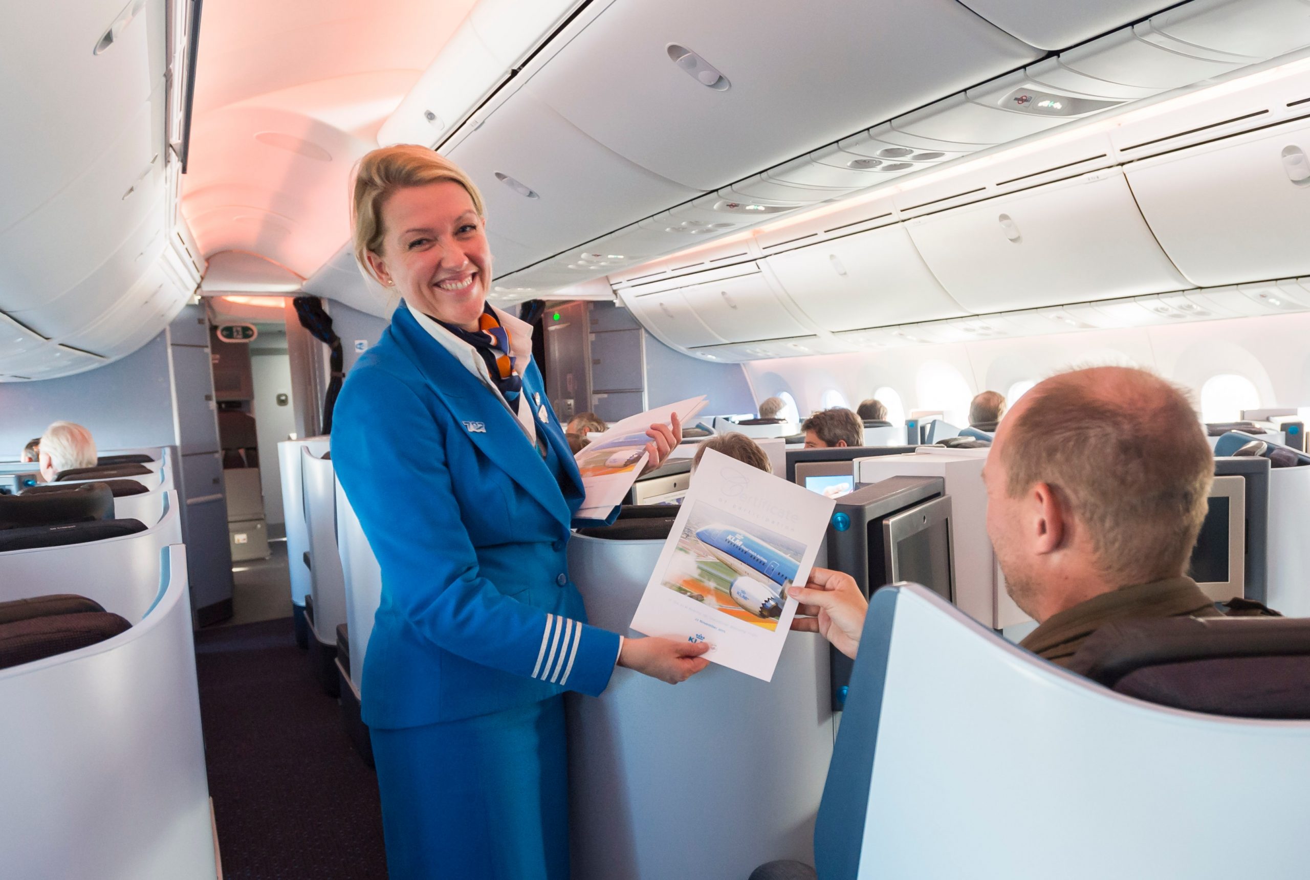 Een passagier ontvangt een certificaat van deelname tijdens KLM’s eerste vlucht met de Boeing 787 Dreamliner vanaf Amsterdam Schiphol.