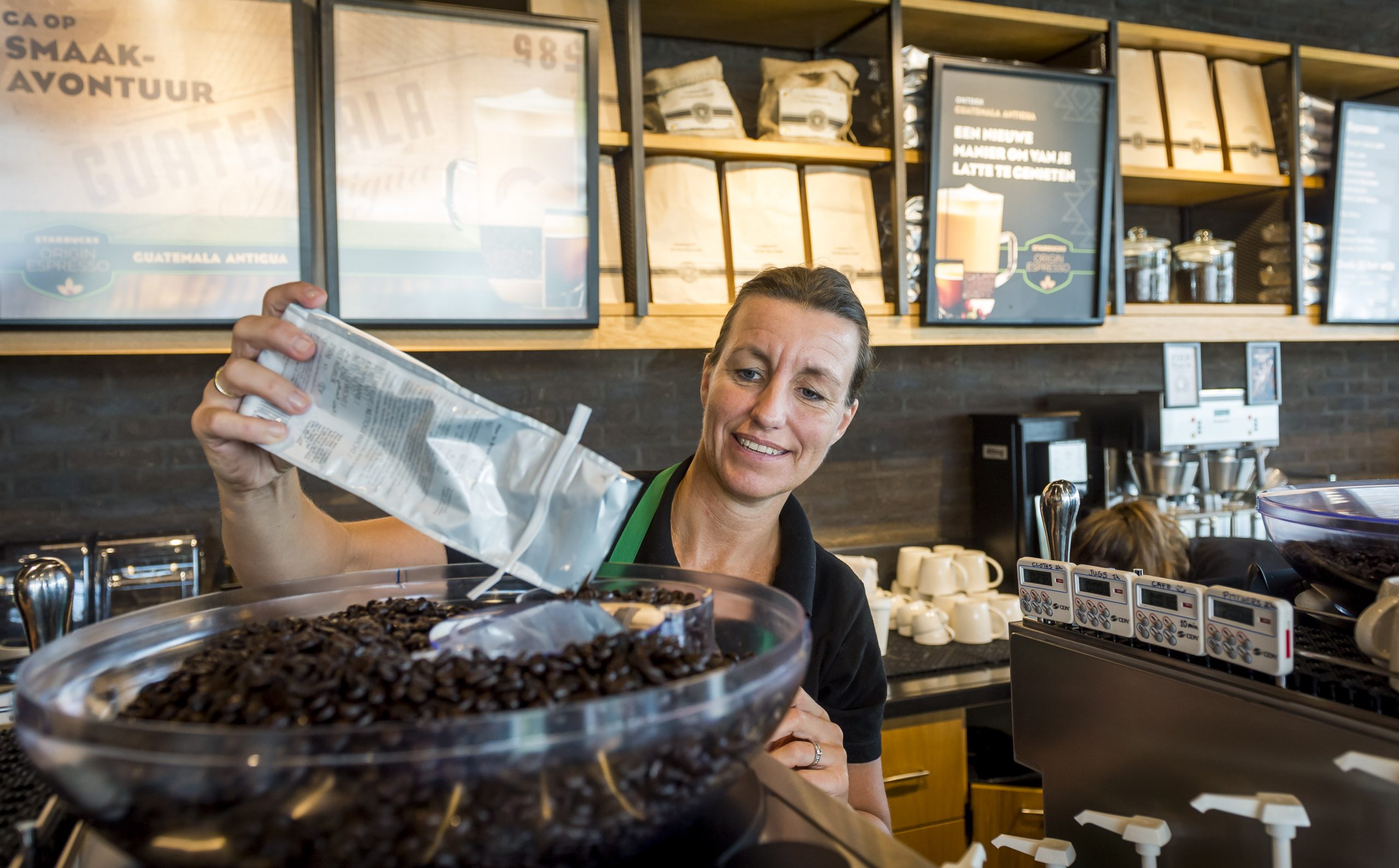 Een medewerker neemt een bestelling op bij Starbucks