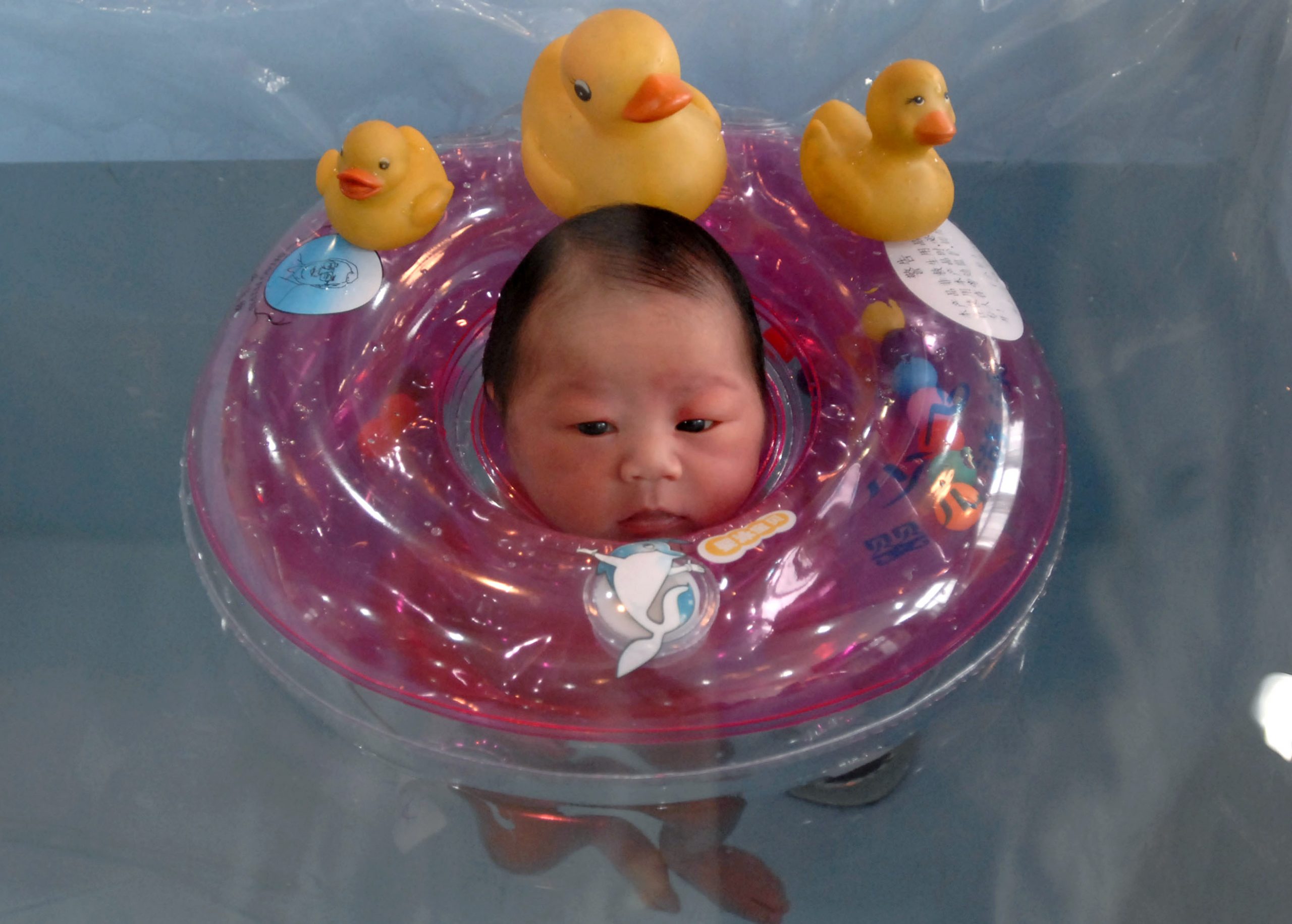 A newborn baby floats in a basin at a hospital in Nanjing, eastern China's Jiangsu province January 12, 2007. China's population will increase by 200 million in the next thirty years, according to a report issued Thursday by the State Population and Family Planning Commission, Xinhua News Agency reported. REUTERS/Leo Lang (CHINA)