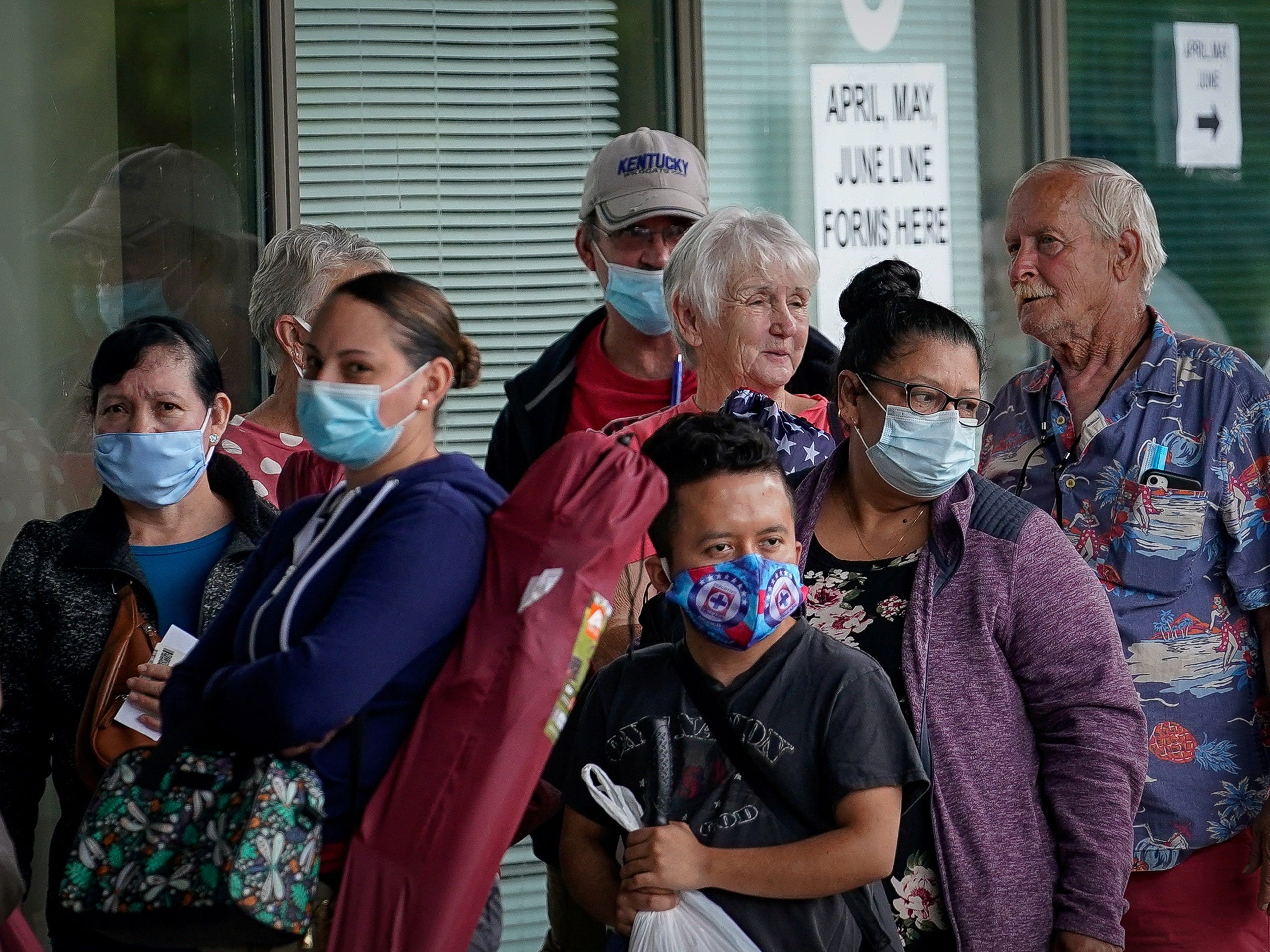 FILE PHOTO: People line up outside a Kentucky Career Center hoping to find assistance with their unemployment claim in Frankfort, Kentucky, U.S. June 18, 2020. REUTERS/Bryan Woolston/File Photo