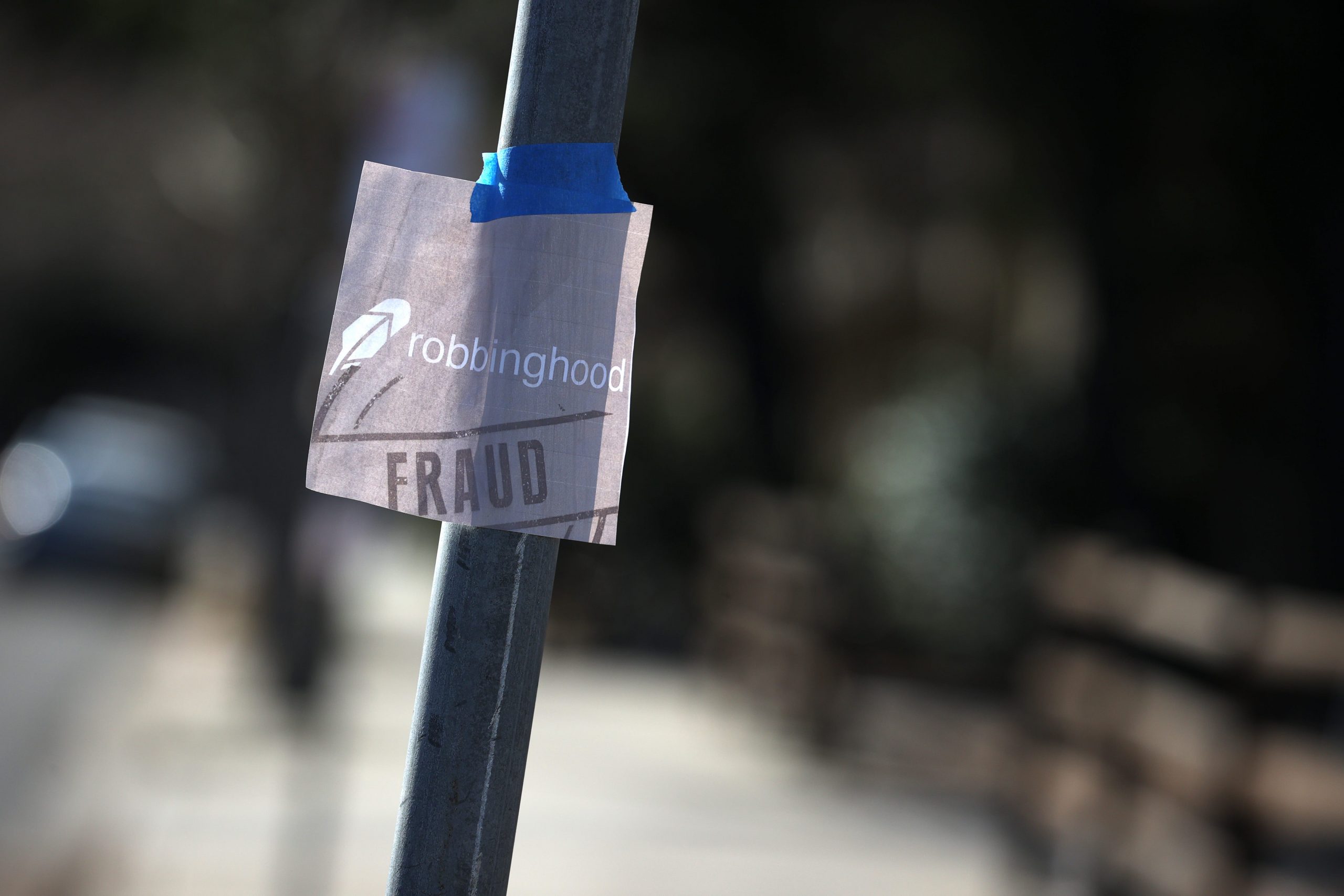 GettyImages 1299843912 MENLO PARK, CALIFORNIA - FEBRUARY 01: A sign reading "Robbinghood Fraud" hangs on a pole in front of the headquarters for trading app Robinhood on February 01, 2021 in Menlo Park, California. Robinhood announced on Monday that it has raised $3.4 billion amid a trading frenzy in the past week. (Photo by Justin Sullivan/Getty Images)