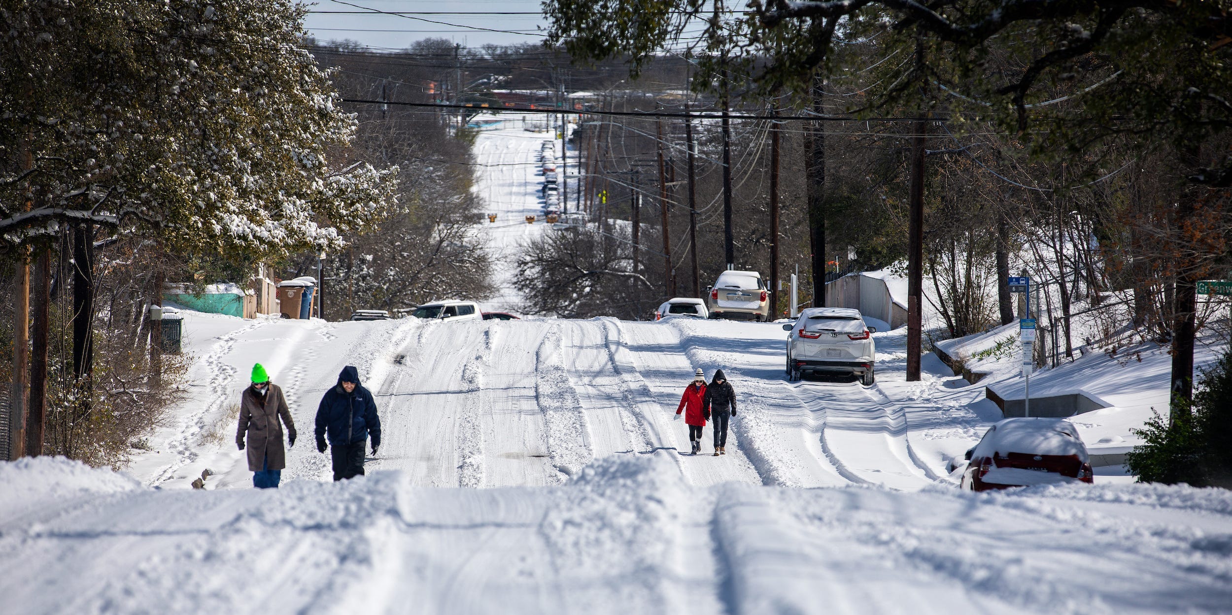 Pedestrians walk on an icy road on February 15, 2021 in East Austin, Texas.