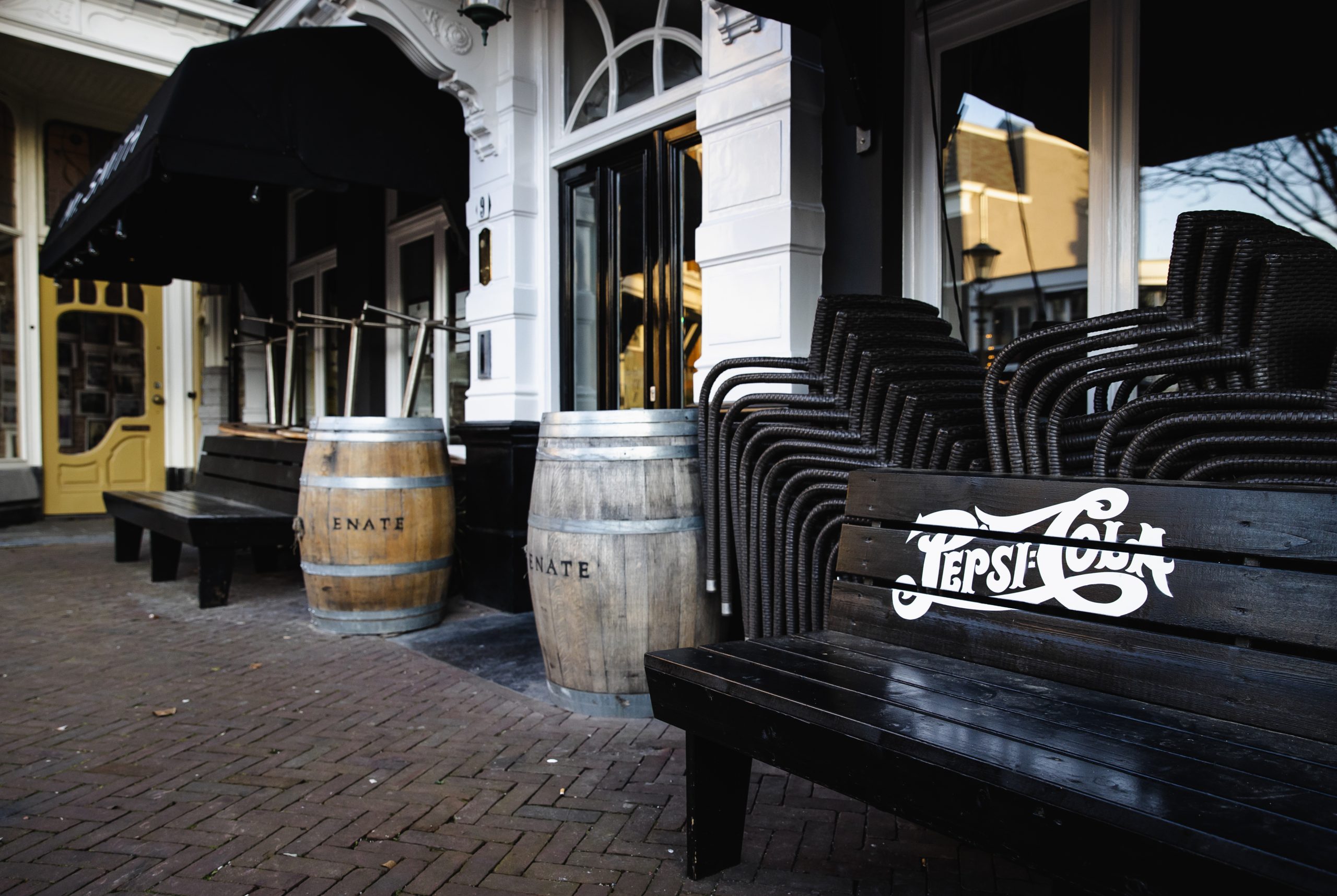 Opgestapelde terrasstoelen bij een horecazaak in Den Haag.