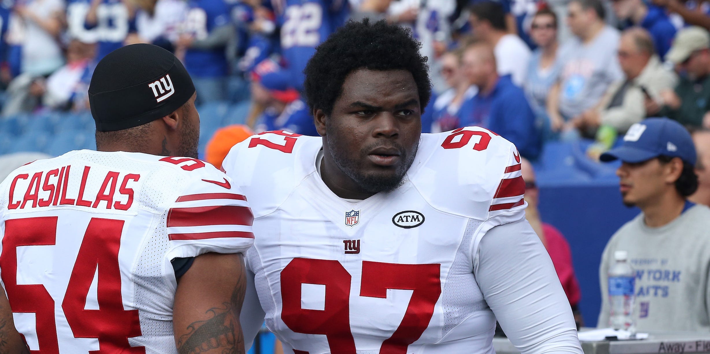 Louis Nix III #97 of the New York Giants with Jonathan Casillas #54 on the sideline during NFL game action against the Buffalo Bills at Ralph Wilson Stadium on October 4, 2015 in Orchard Park, New York.