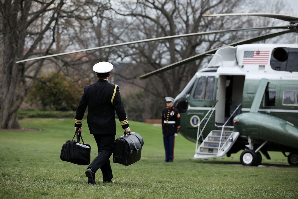 A White House military aide carries the nuclear "football" as he leaves the White House