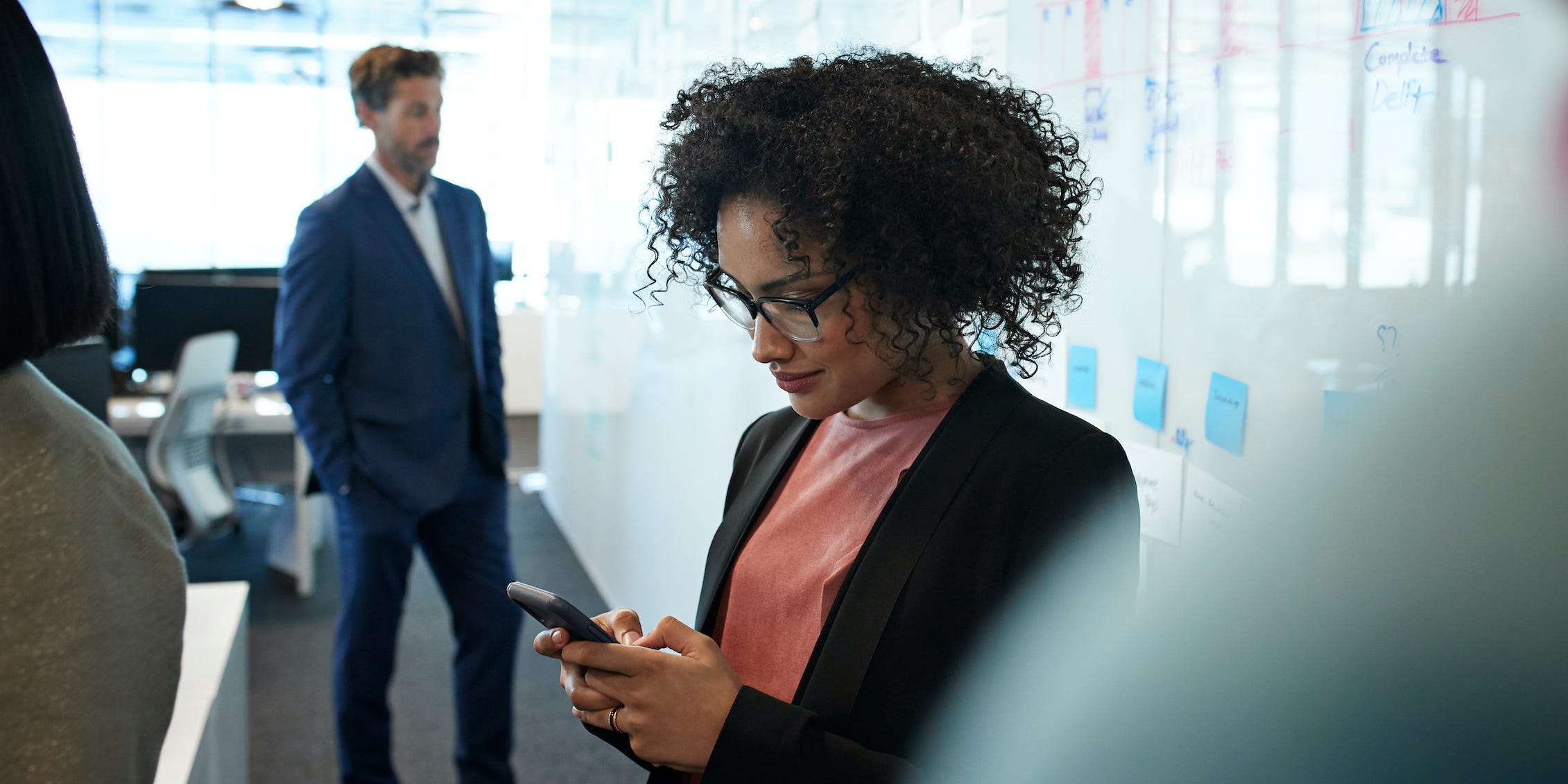 woman in office using smartphone