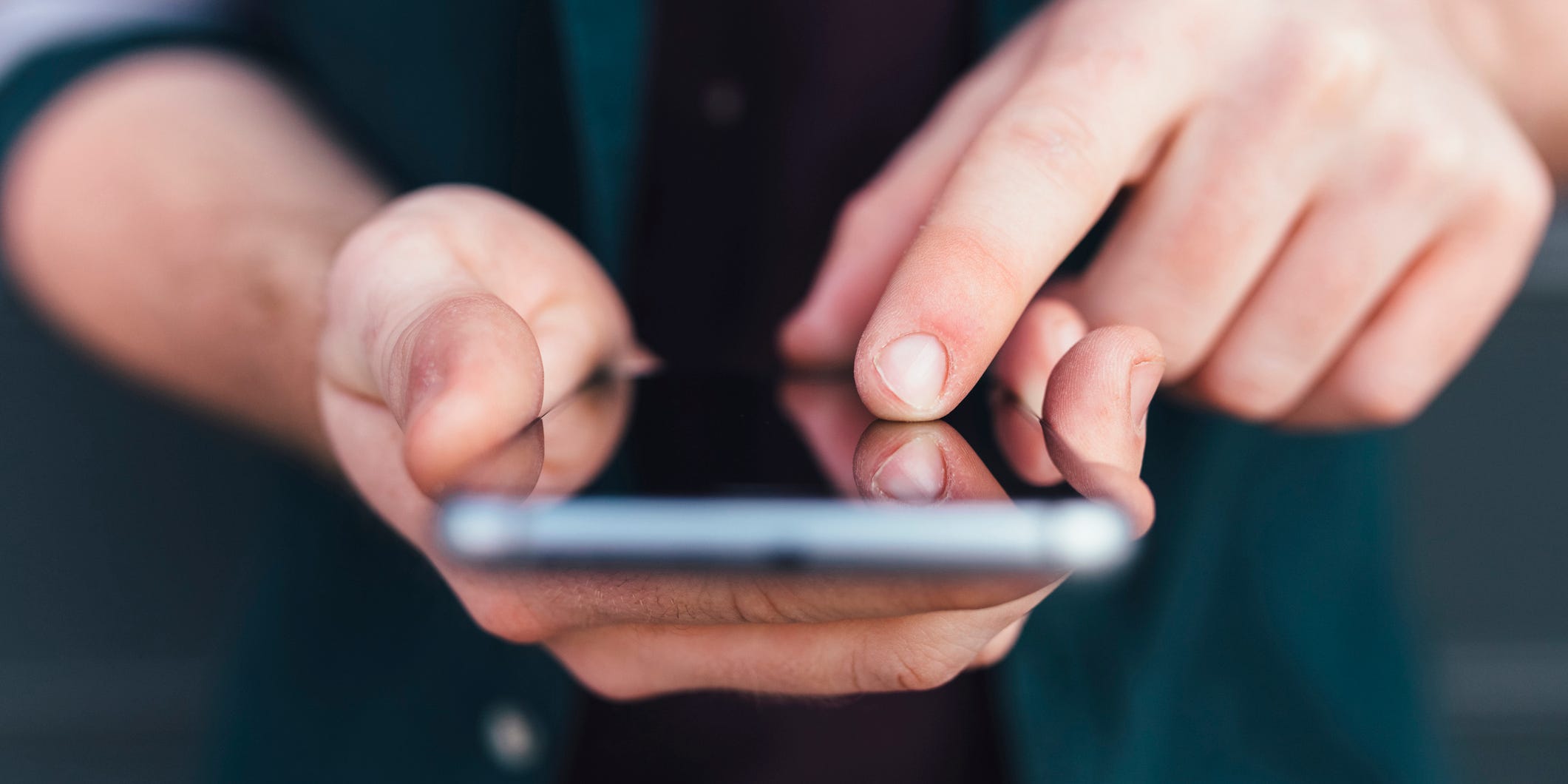 Index finger of young man touching smartphone