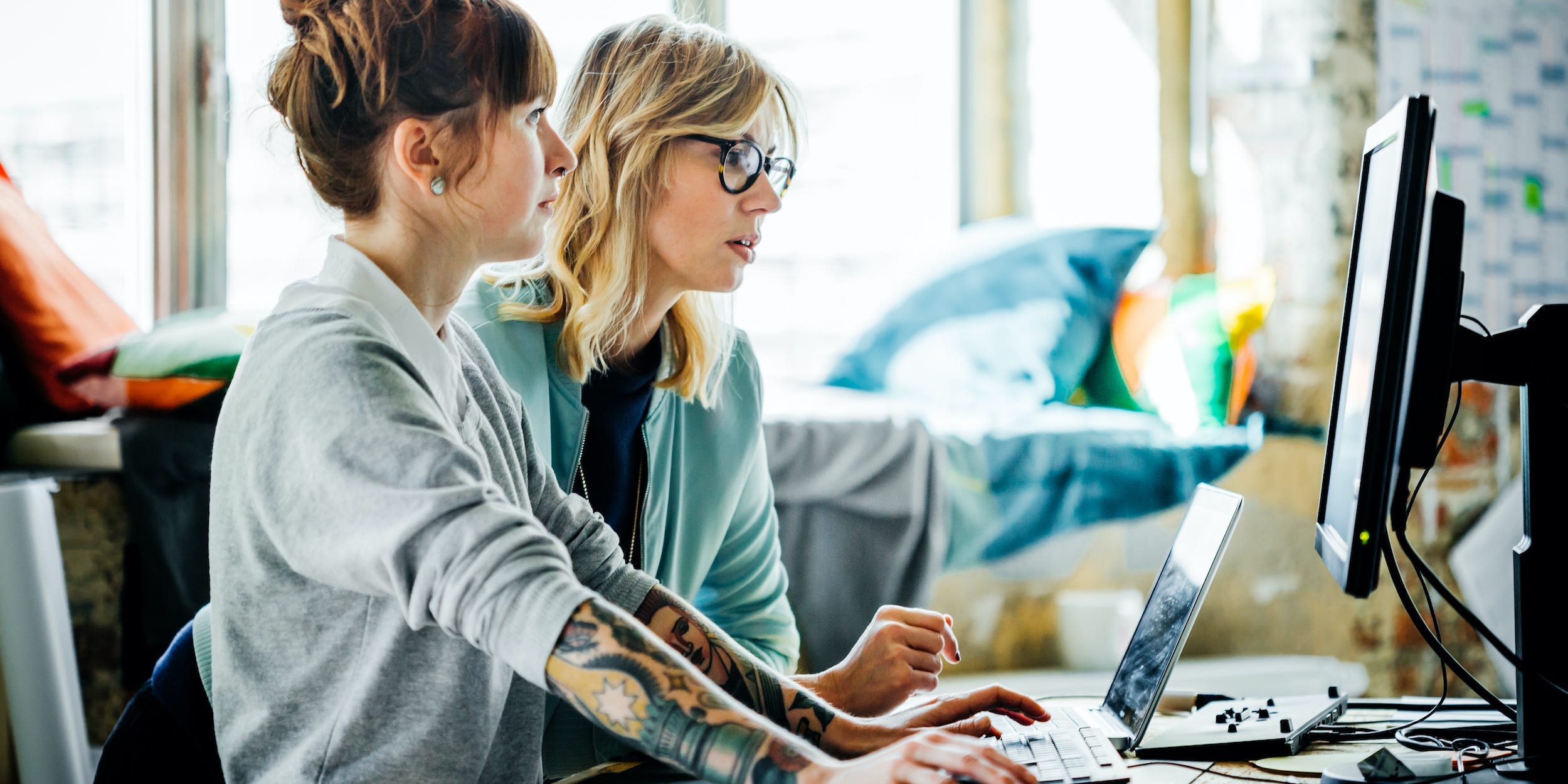 business professionals working together at desktop laptop in office