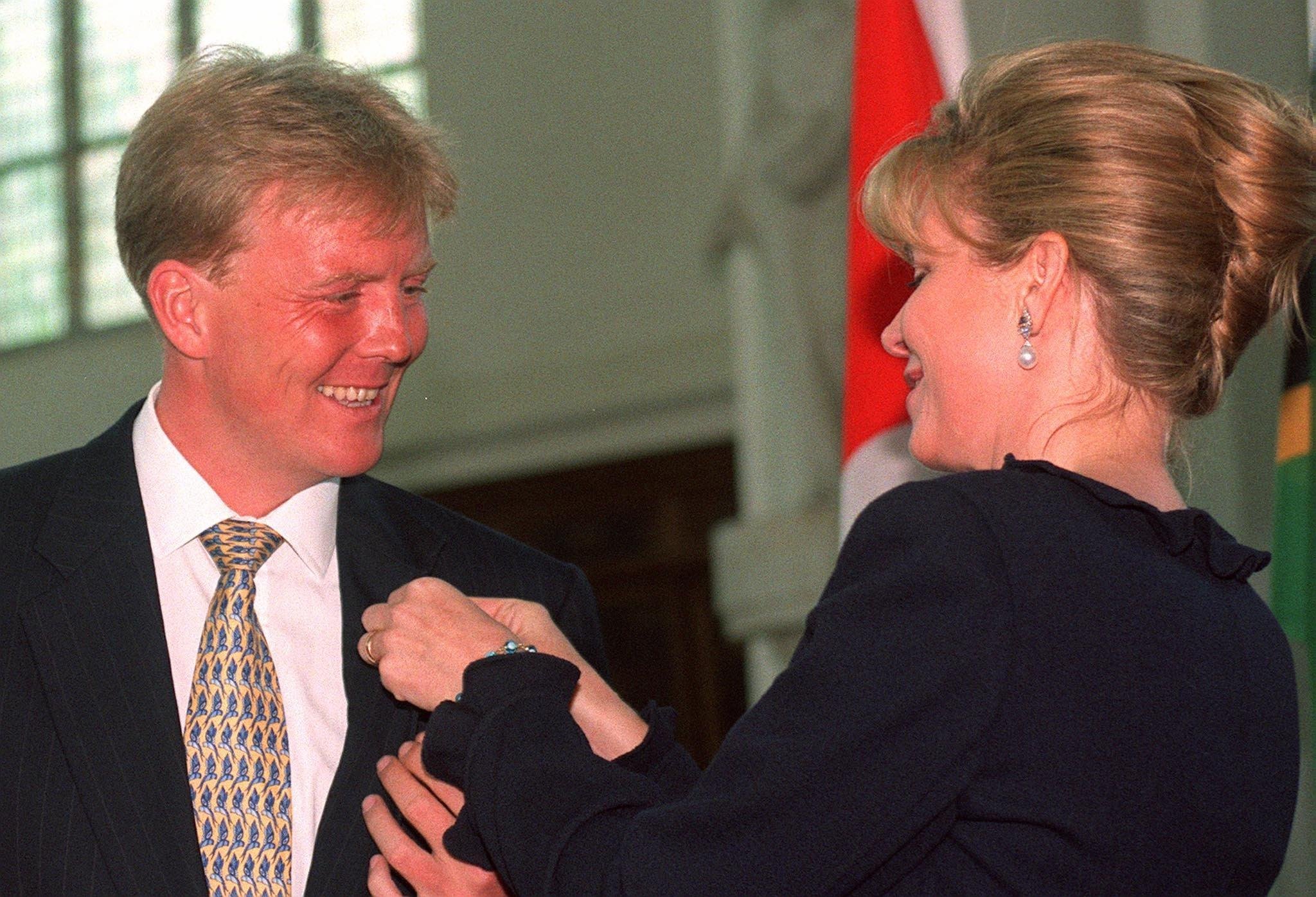 Toenmalig kroonprins Willem Alexander krijgt in 1999 in Den Haag van koningin Noor van Jordanië een speldje dat hoort bij het beschermheerschap van de Vereniging United World Colleges Nederland. Foto: ANP
