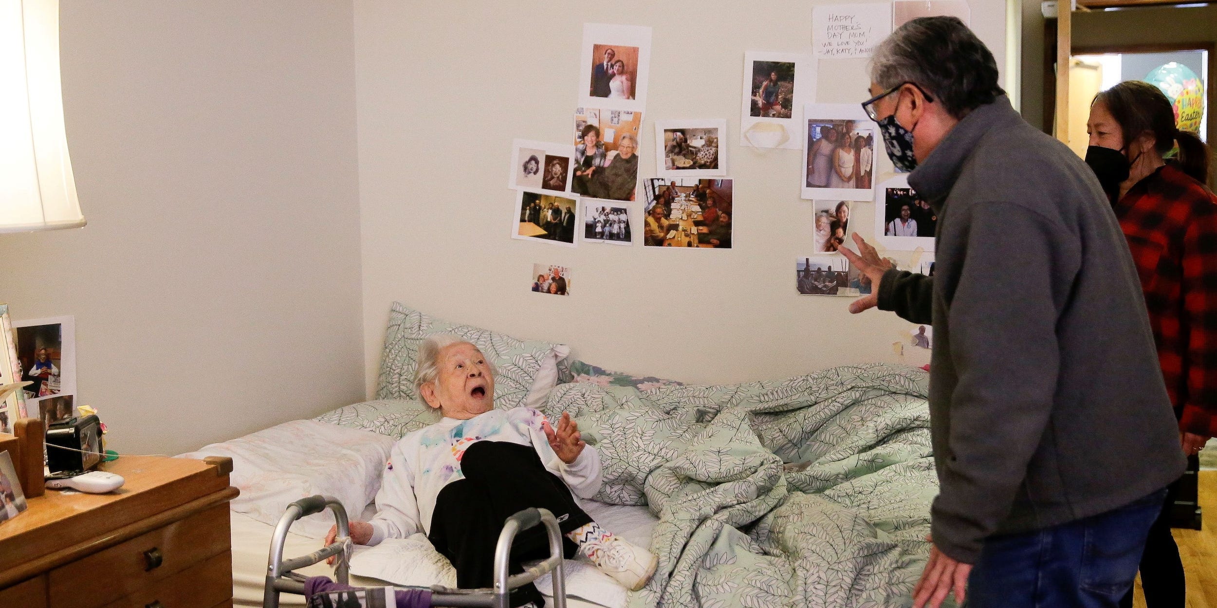 Yoshia Uomoto, 98, reacts as her son Mark Uomoto and niece Gail Yamada surprise her with their first in-person visit in a year after indoor visitation restrictions due to the coronavirus disease (COVID-19) were lifted at Nikkei Manor, an assisted living facility primarily serving Japanese-American seniors, in Seattle, Washington, U.S. March 30, 2021.