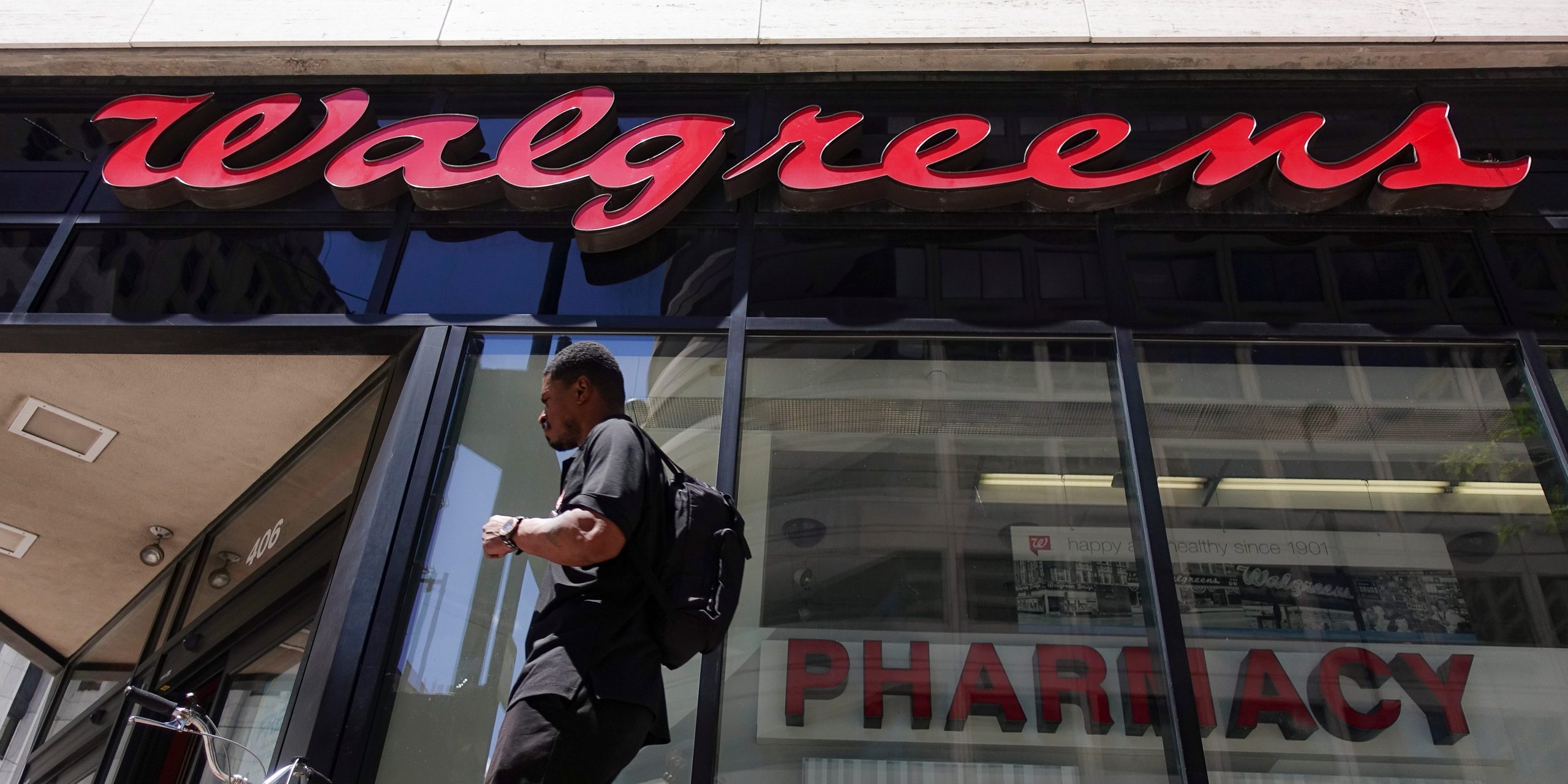 FILE - In this June 25, 2019, file photo signage hangs outside a Walgreens pharmacy in downtown Cincinnati. Walgreens reports financial results on Wednesday, Jan. 8, 2020. (AP Photo/John Minchillo, File)