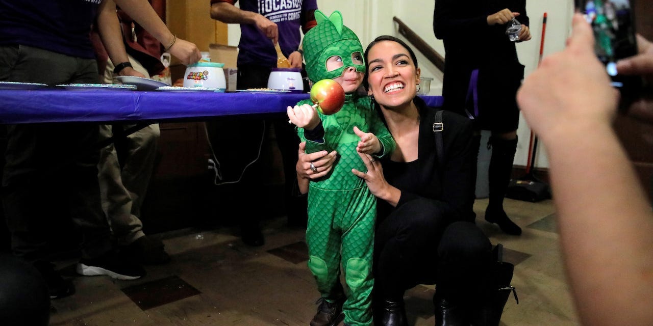 Democratic Congressional candidate Alexandria Ocasio-Cortez poses with a child in costume as she attends the "Halloween with Alexandria" event at St Paul's Evangelical Lutheran Church in the Bronx, New York, U.S., October 31, 2018.