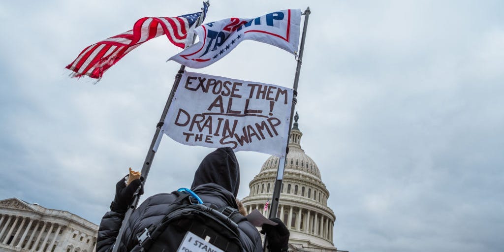 A man holding signs and flags in support of President Donald Trump is seen in front of the Capitol Building on January 6, 2021 in Washington, DC.