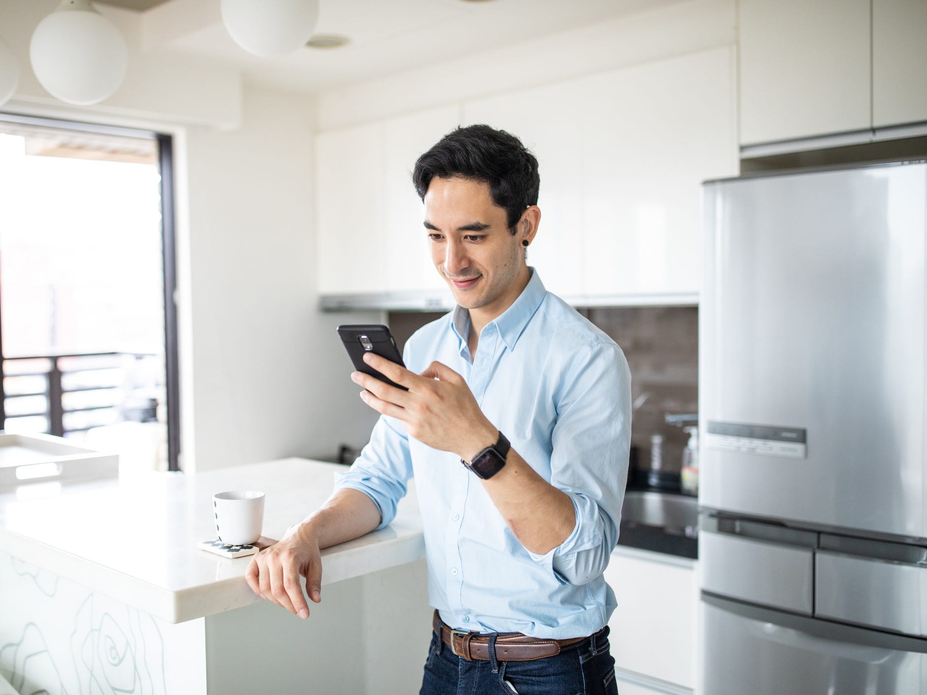 man with hearing device using phone