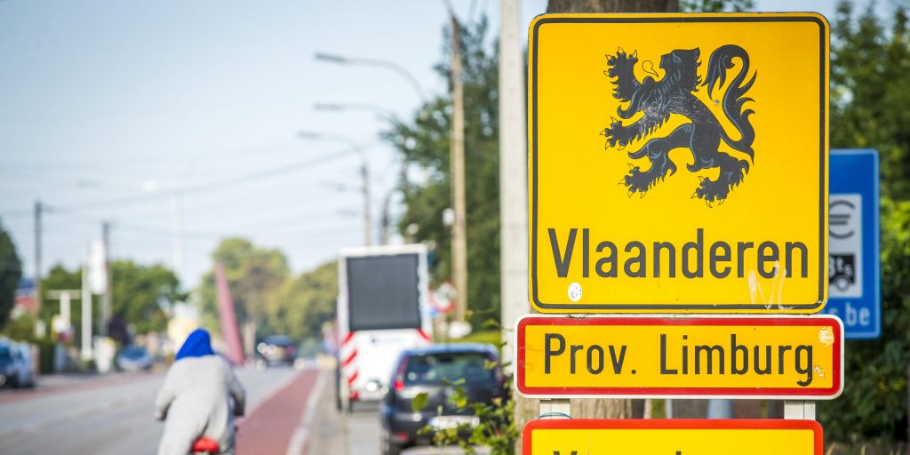 Een fietser passeert de grens tussen België en Nederland.