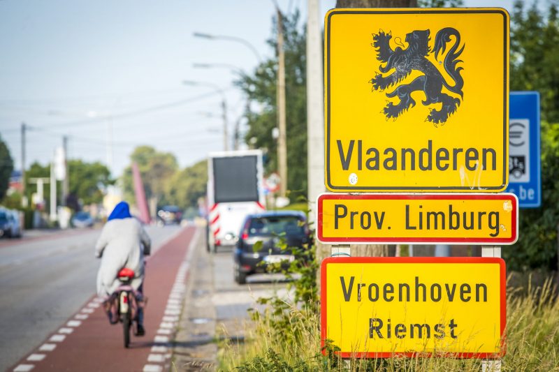 Een fietser passeert de grens tussen België en Nederland.