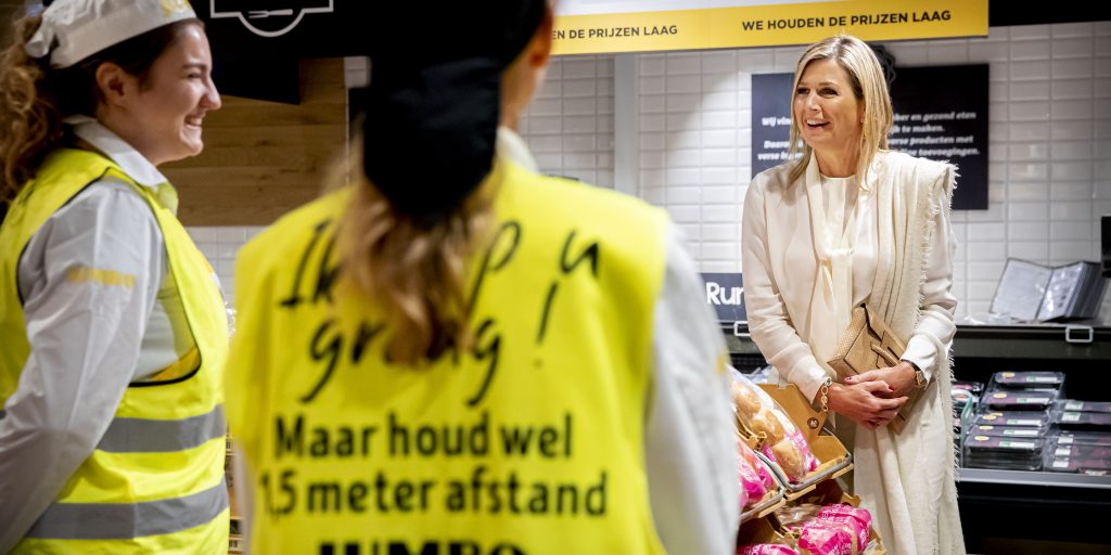 Koningin Maxima spreekt met medewerkers tijdens een bezoek aan een Jumbo supermarkt in Nijmegen.