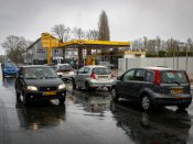 Nederlandse automobilisten staan in een rij te wachten bij een pompstation in Gronau, net over de grens bij Enschede.