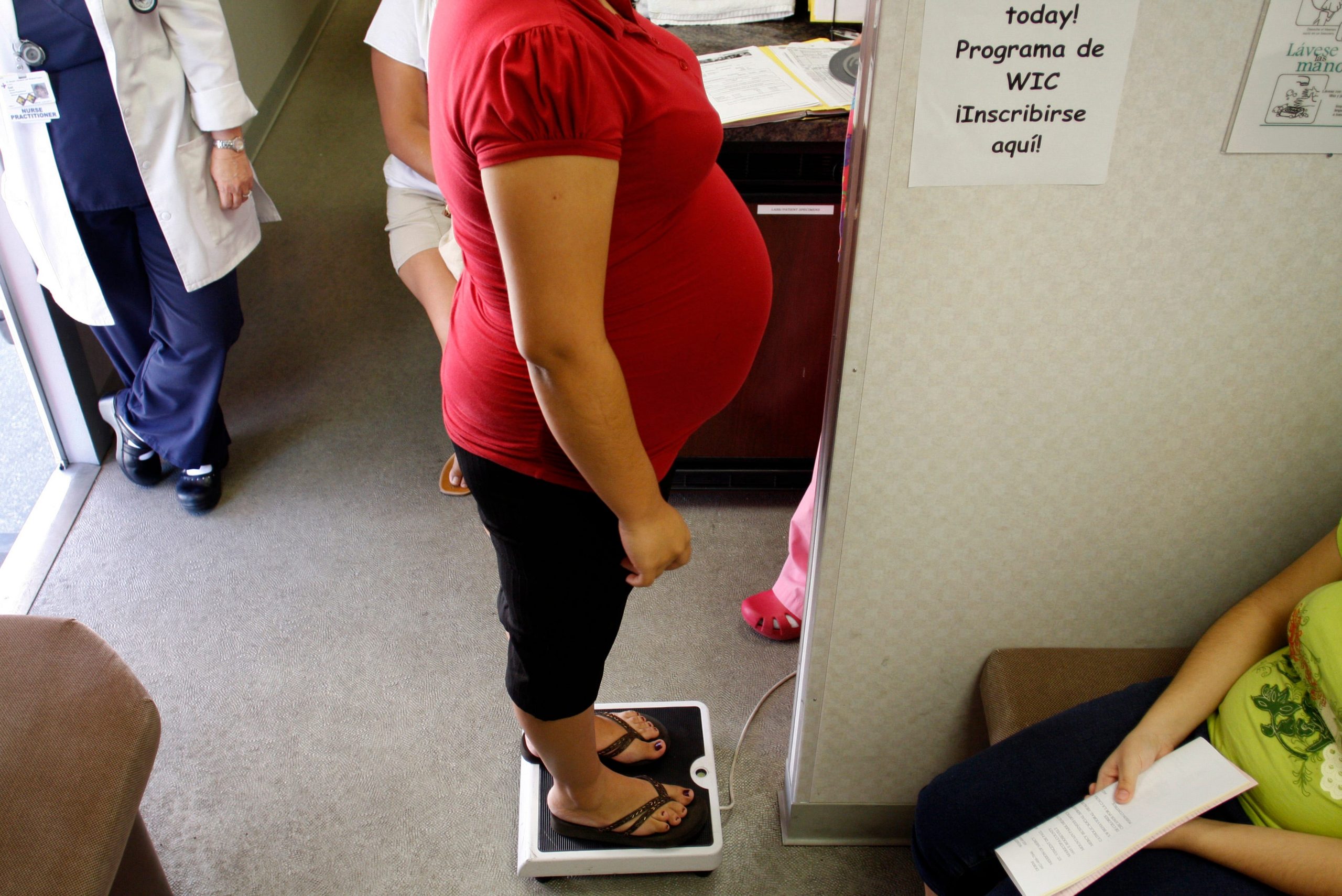 FILE PHOTO: A pregnant woman stands on a scale before receiving a prenatal exam at the Maternity Outreach Mobile in Phoenix, Arizona October 8, 2009. REUTERS/Joshua Lott 