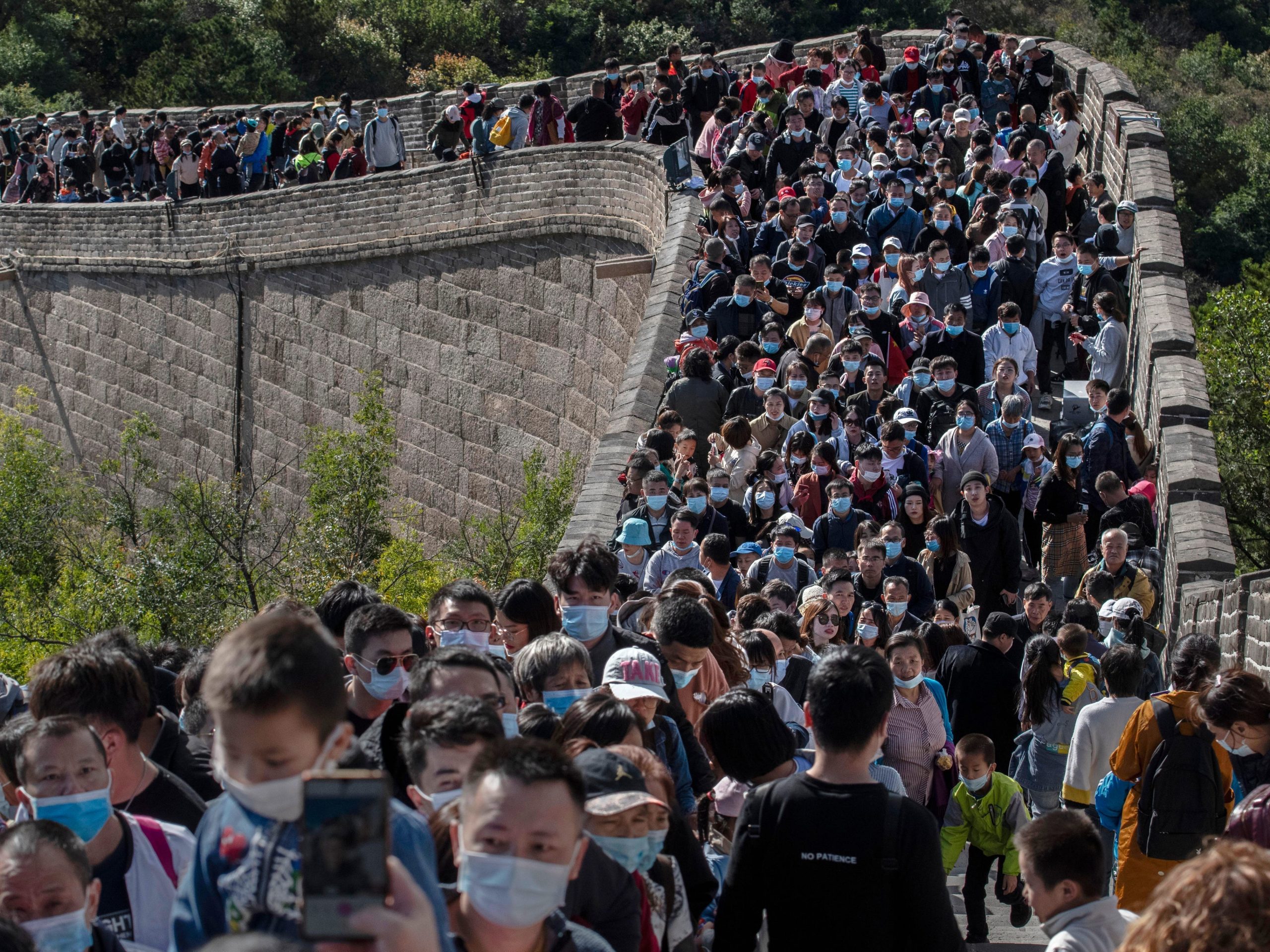 BEIJING, CHINA - OCTOBER 04: Chinese tourists crowd in a bottleneck as they move slowly on a section of the Great Wall at Badaling after tickets sold out during the 'Golden Week' holiday on October 4, 2020 in Beijing, China. Officials are expecting the Golden Week holiday to boost China's consumer economy as people were encouraged to use the 8-day break to travel and spend. Tourist sites including the Great Wall were packed, with tickets selling out most days given pandemic restrictions and capacity capped at 75%. (Photo by Kevin Frayer/Getty Images)