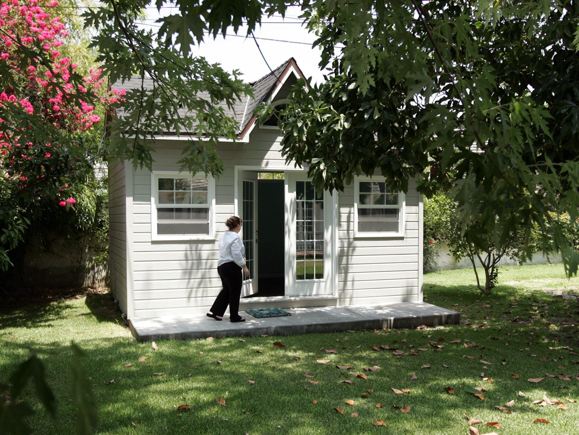 A woman walks into a backyard "she-shed"