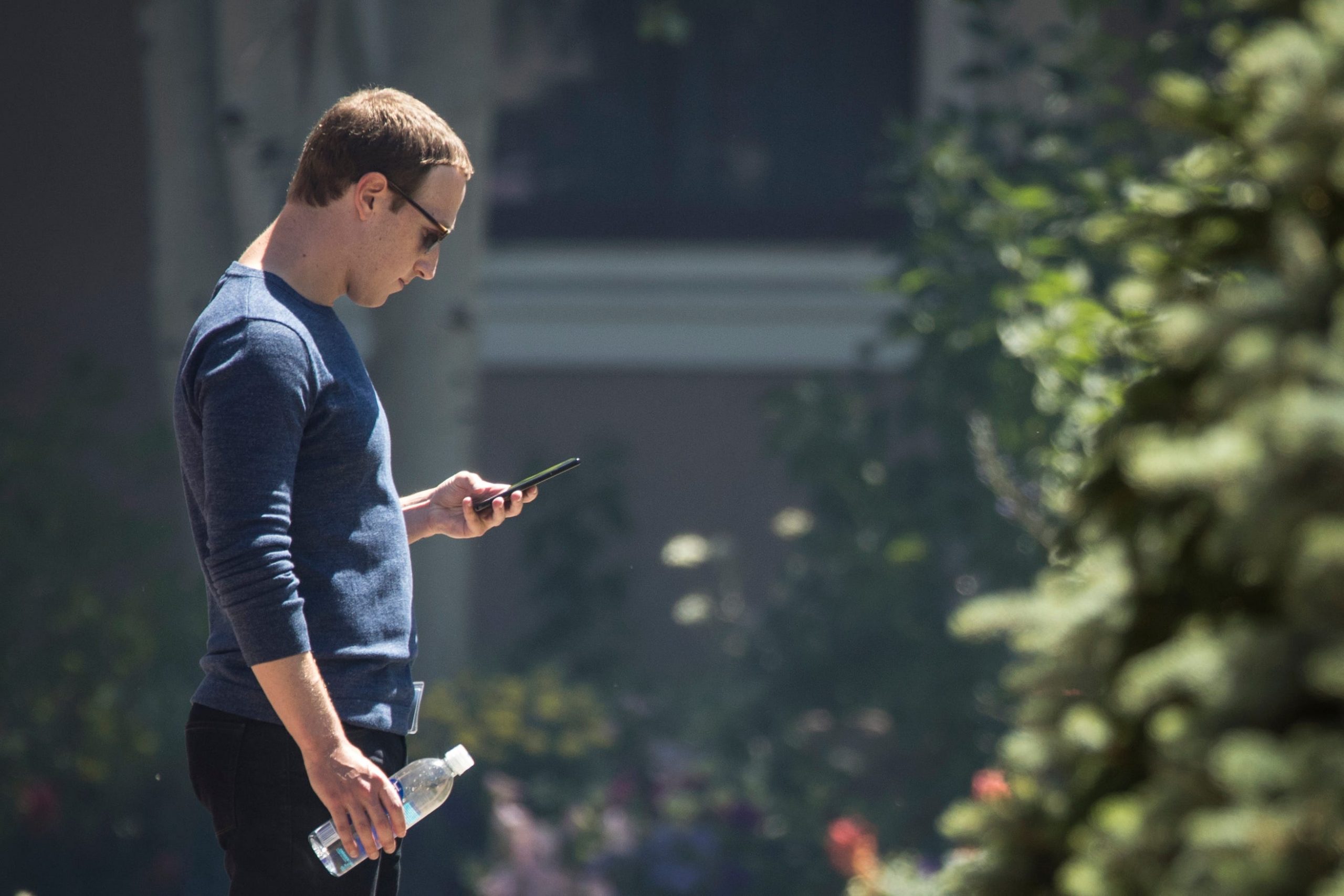 Facebook CEO Mark Zuckerberg looks at his phone.