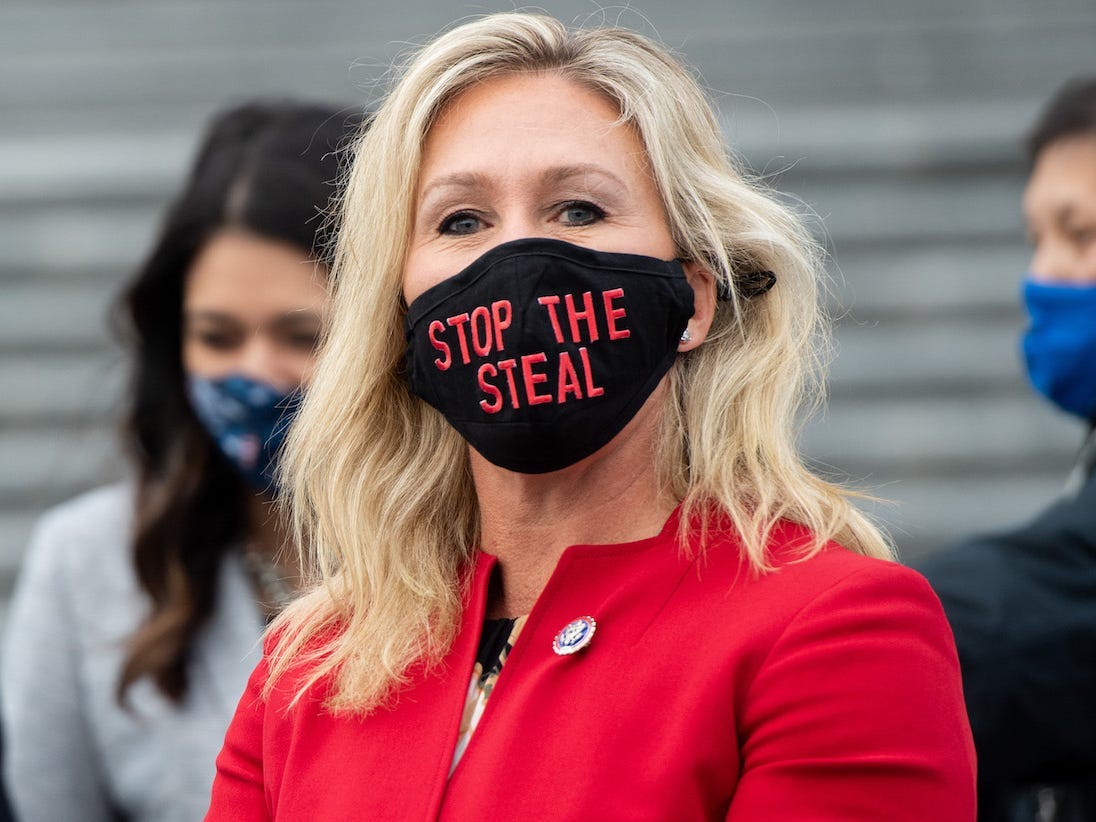 Marjorie Taylor Greene, Republican of Georgia, holds up a "Stop the Steal" mask while speaking with fellow first-term Republican members of Congress on the steps of the US Capitol in Washington, DC, January 4, 2021.