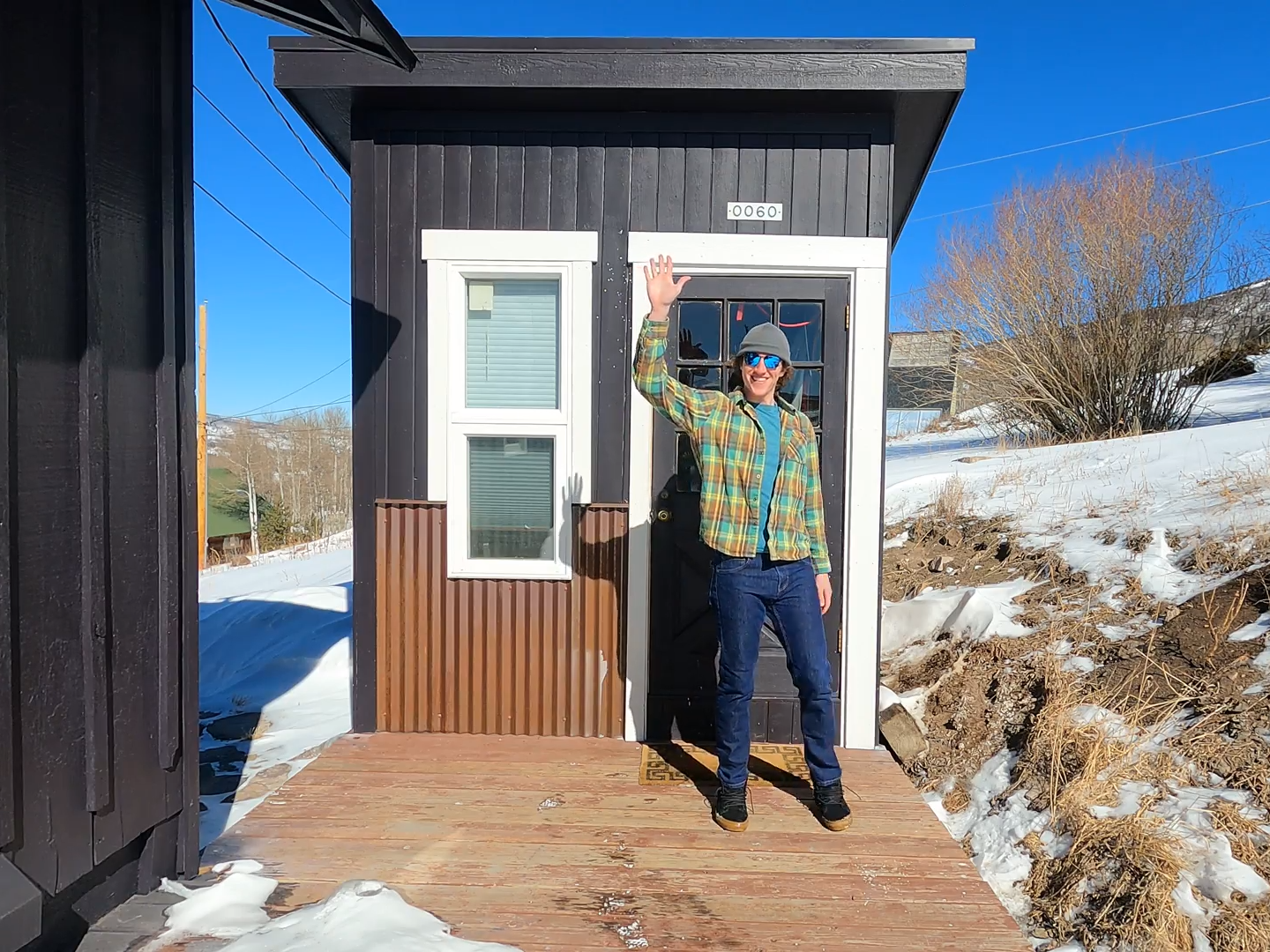 Keenan Laurence smiley in front of tiny home