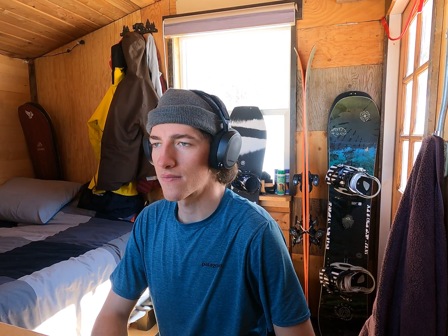 Keenan Laurence working at desktop with snowboards in background