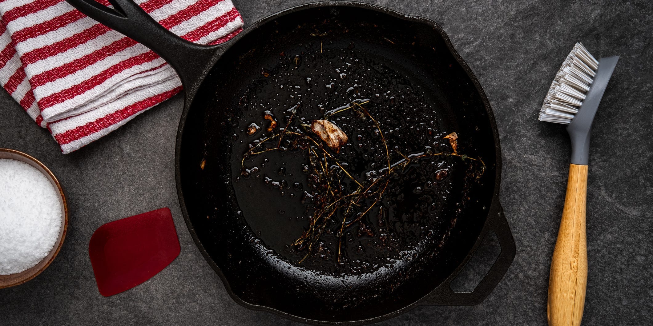 Dirty cast iron skillet being prepped for cleaning