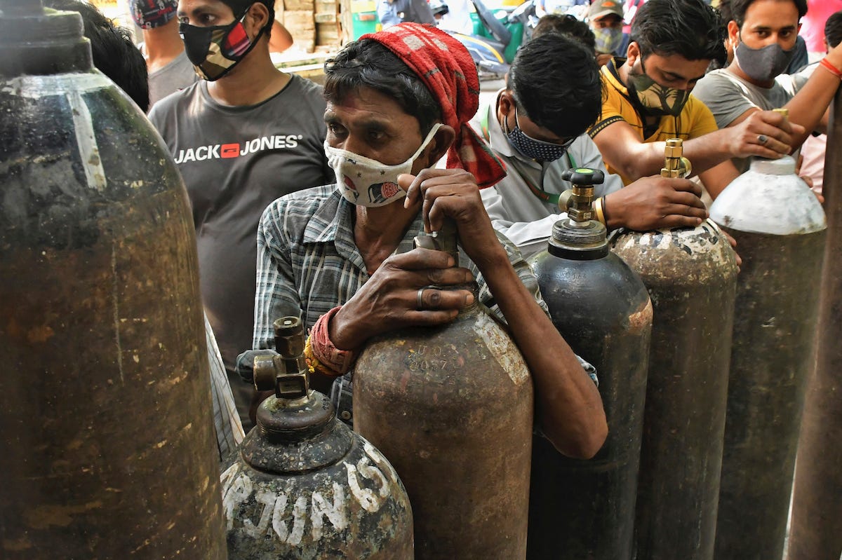Indians wait in line to refill oxygen cylinders for COVID-19 patients