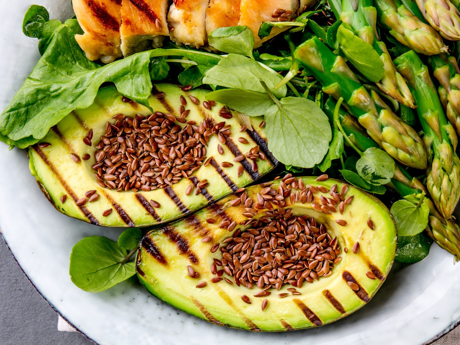 Grilled avocado in a salad topped with seeds