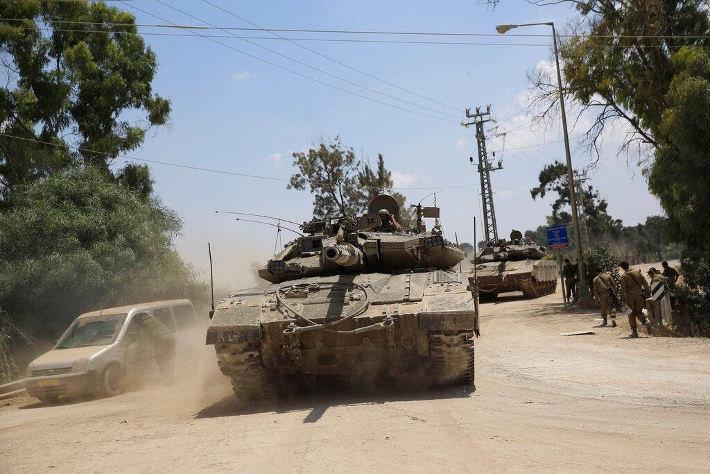 Israeli tanks ride along the border of Israel and the Gaza Strip, Sunday, July 20, 2014.