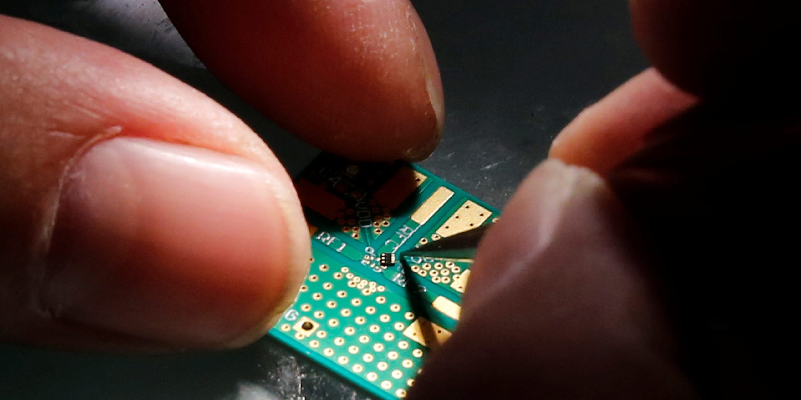 FILE PHOTO - A researcher plants a semiconductor on an interface board during a research work to design and develop a semiconductor product at Tsinghua Unigroup research centre in Beijing, China, February 29, 2016.  REUTERS/Kim Kyung-Hoon