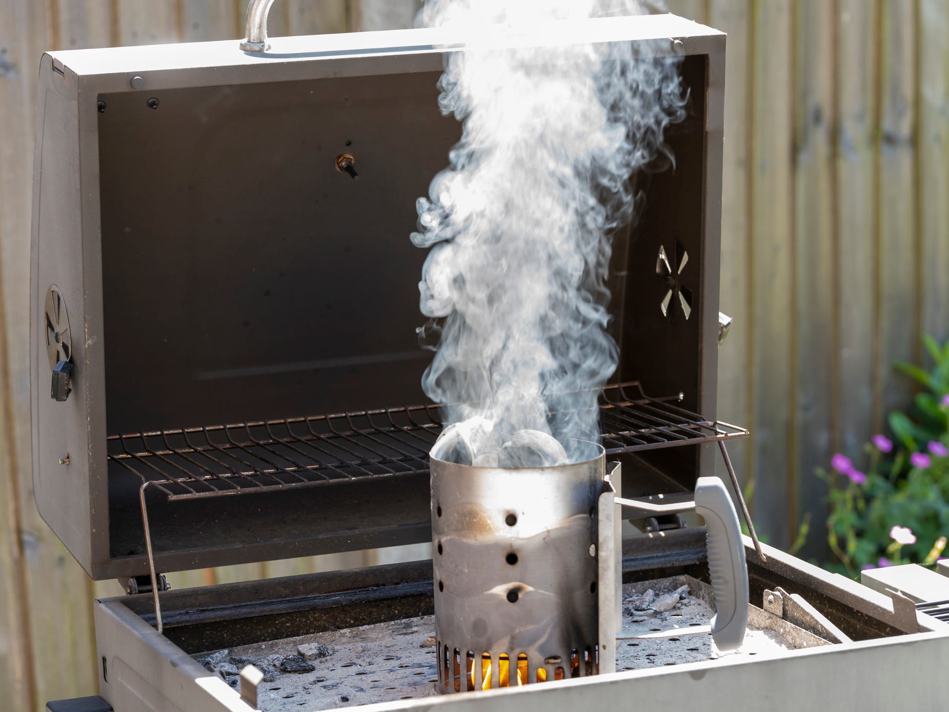 Charcoal chimney starter sitting inside a grill