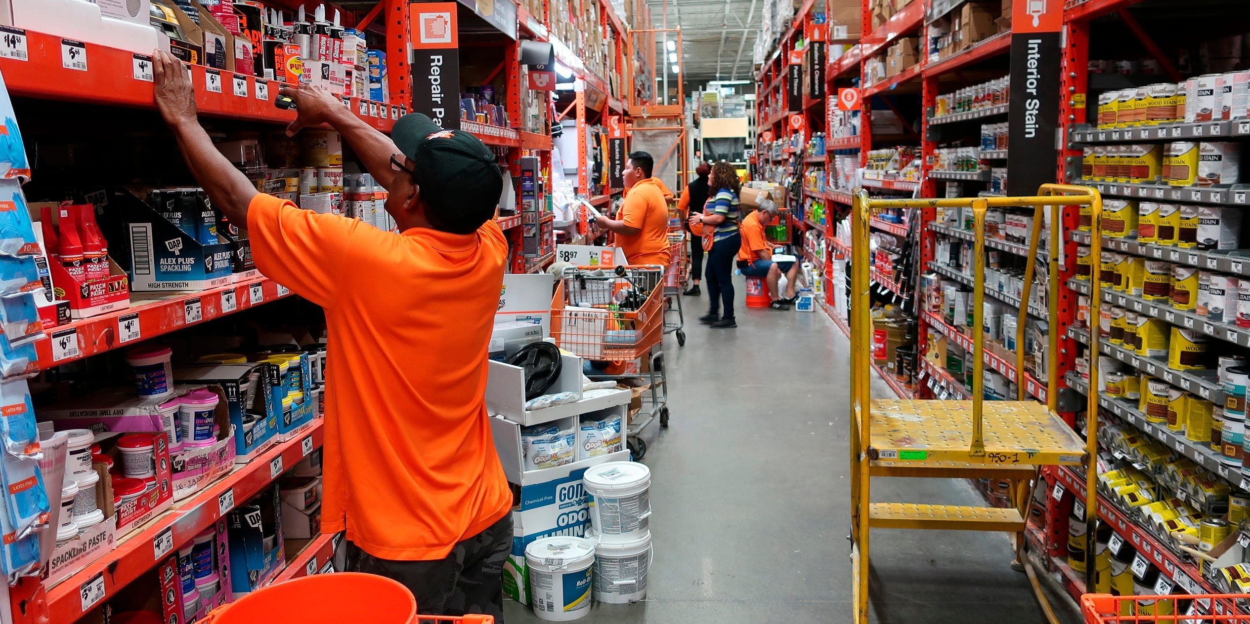 FILE- In this Aug. 14, 2018, file photo workers stock the shelves at a Home Depot store in Passaic, N.J. Home Depot Inc. reports financial results Tuesday, Feb. 26, 2019. (AP Photo/Ted Shaffrey, File)