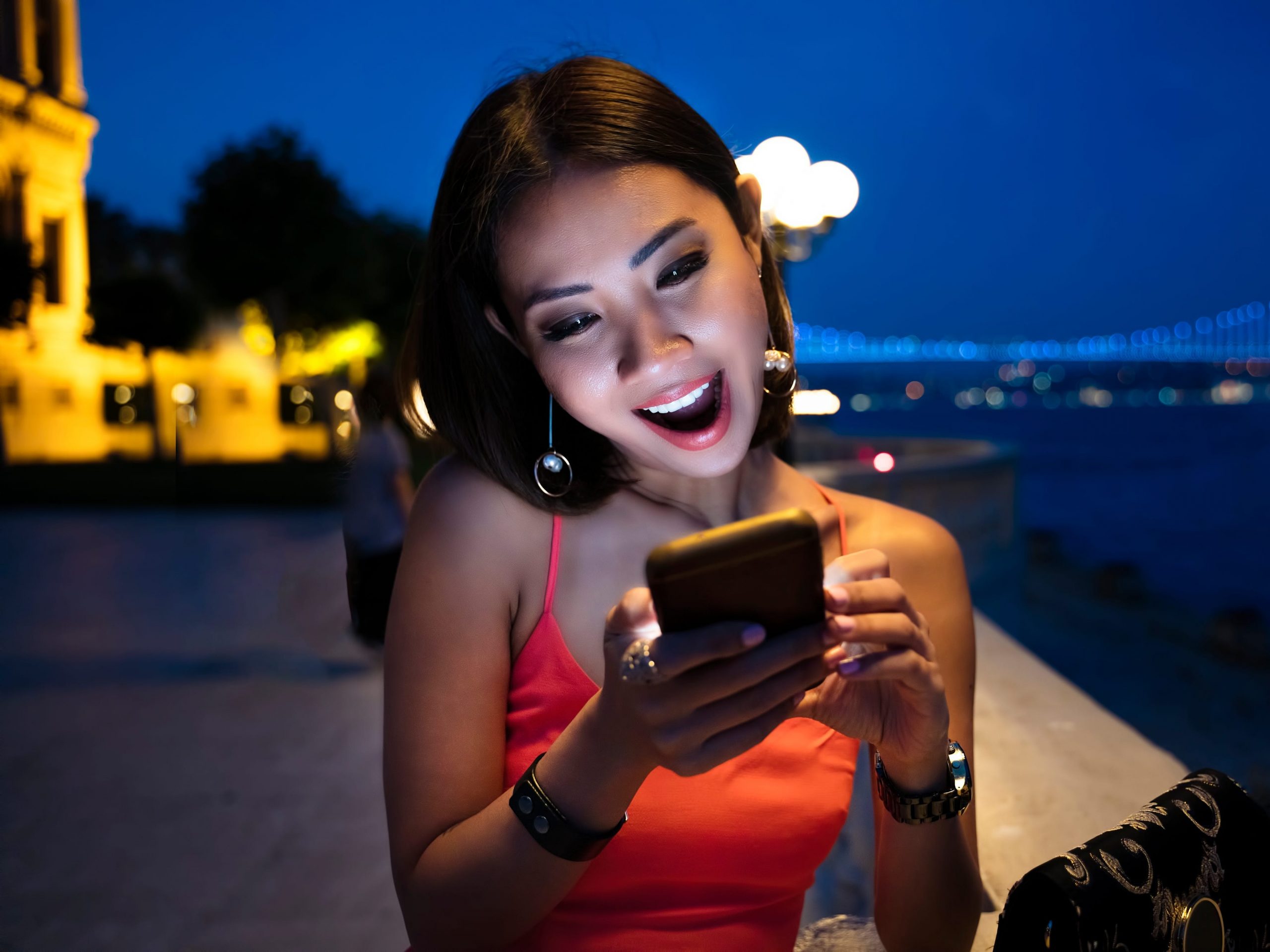 A woman scrolls through a dating app on her cell phone.