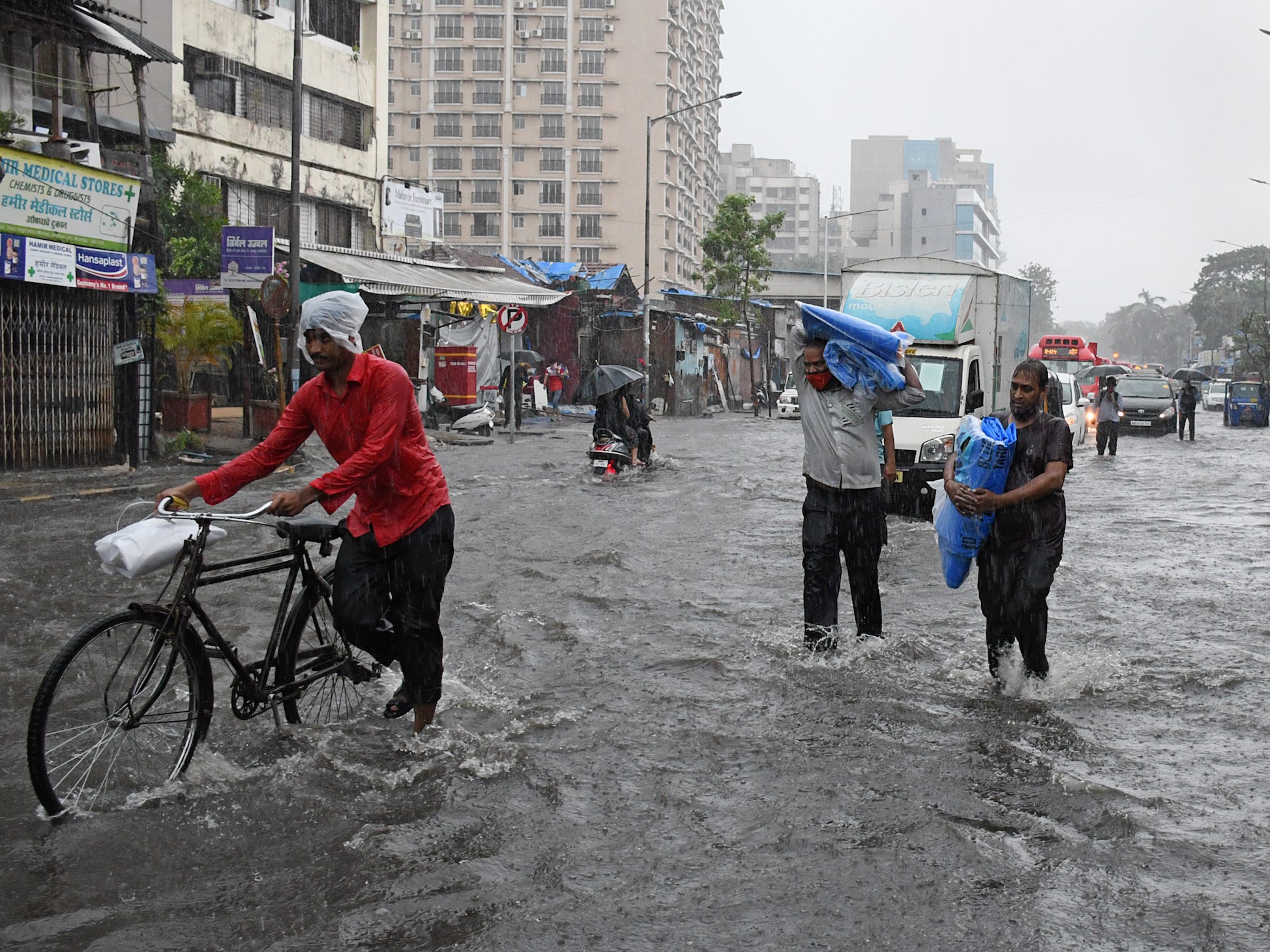 People wade through a flooded street due to heavy rain caused by cyclone 'Tauktae' in Mumbai.