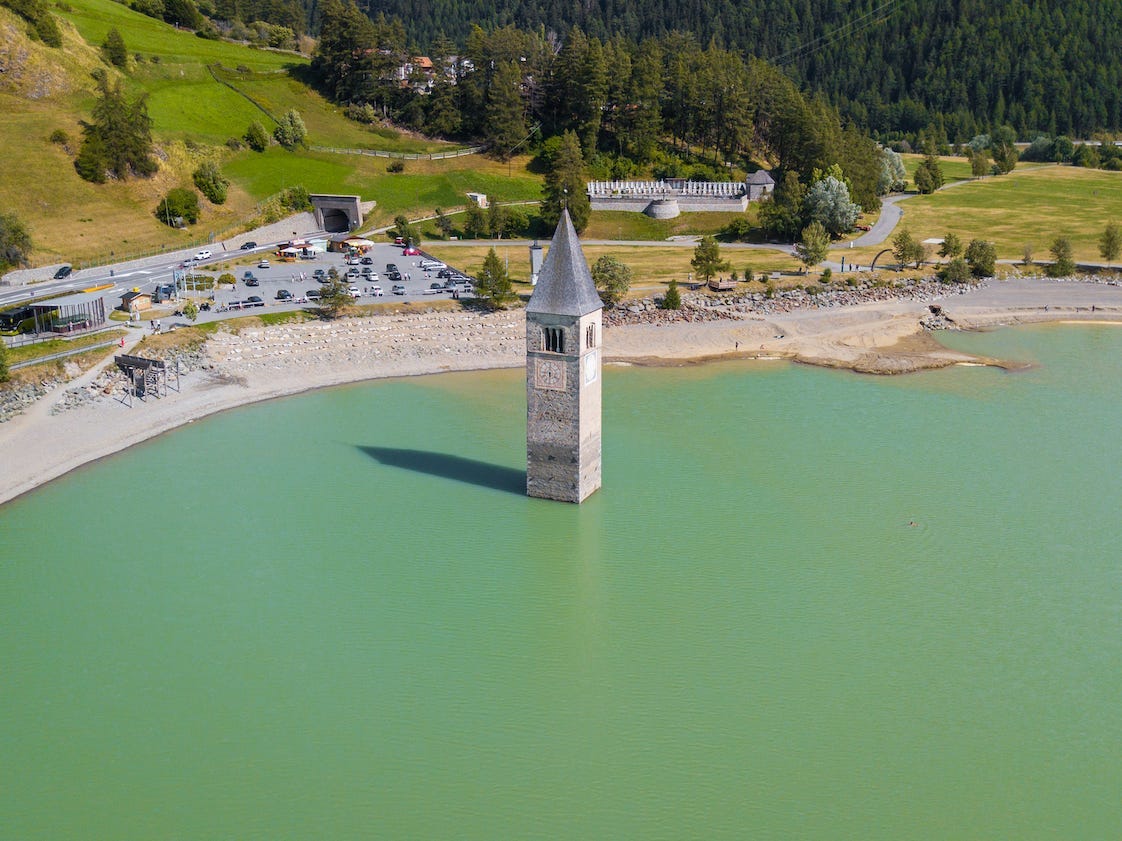 Drone aerial view of the old bell tower of the village rising out of the waters of Lake Resia.